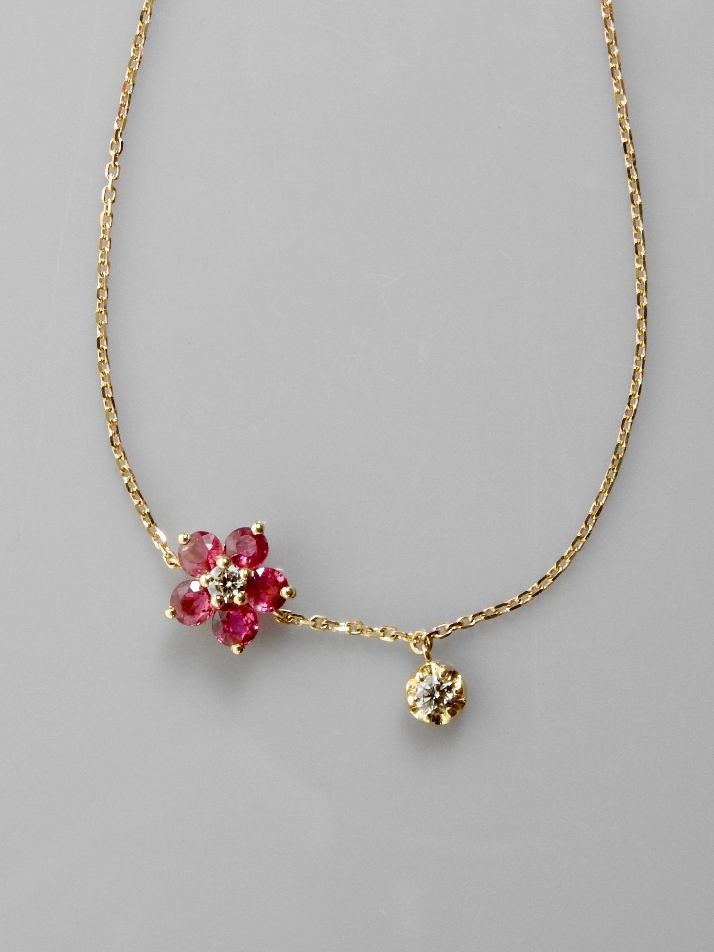 Null 玫瑰金手镯，750毫米，中心是一朵饰有钻石和五颗红宝石的花，衬托着一颗钻石，总重约0.80克拉，弹簧环扣，可调长度17.5厘米，重量：1.6克。