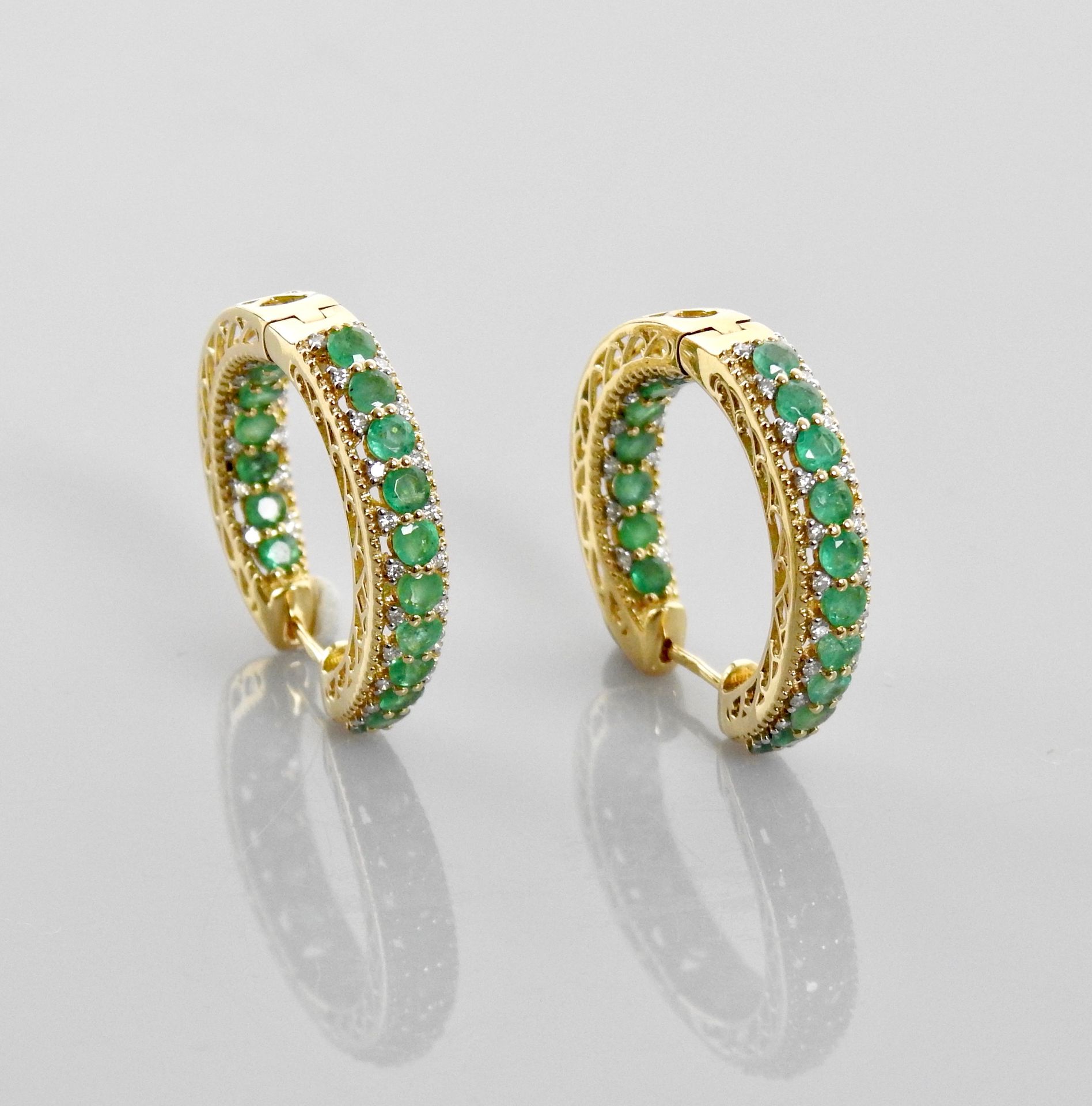 Null Yellow gold hoop earrings, 750 MM, highlighted with round emeralds framed w&hellip;