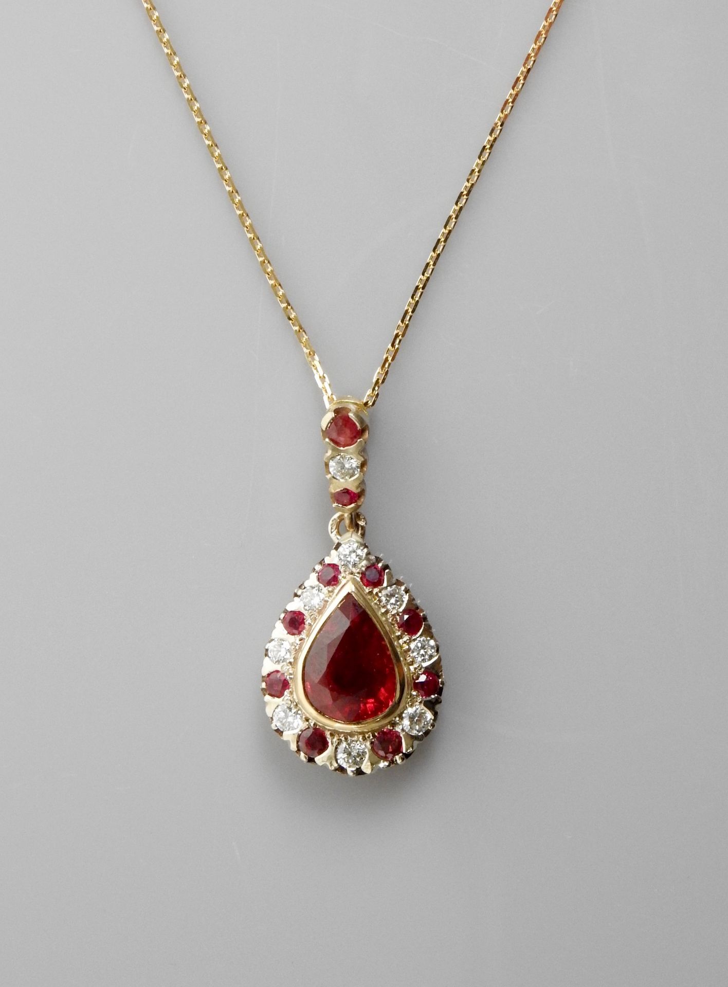 Null 双金项链和吊坠，750毫米，镶有一颗重达3克拉的梨形切割红宝石，周围有红宝石和钻石，30 x 15毫米，龙虾扣，长45厘米，重量：8.65克，毛重。