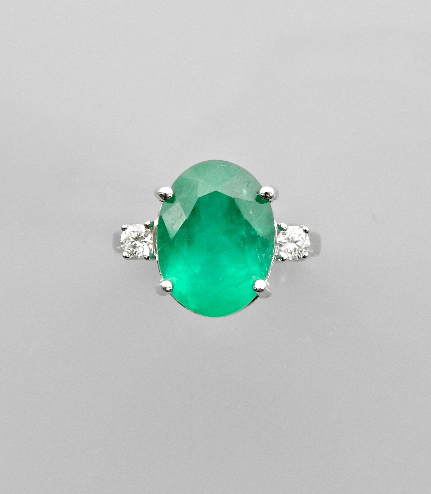 Null 白金戒指，750毫米，镶嵌着一个非常漂亮的椭圆形祖母绿，重7.06克拉，产地哥伦比亚，位于两颗钻石之间，尺寸：54，重量：5.9克，毛重。