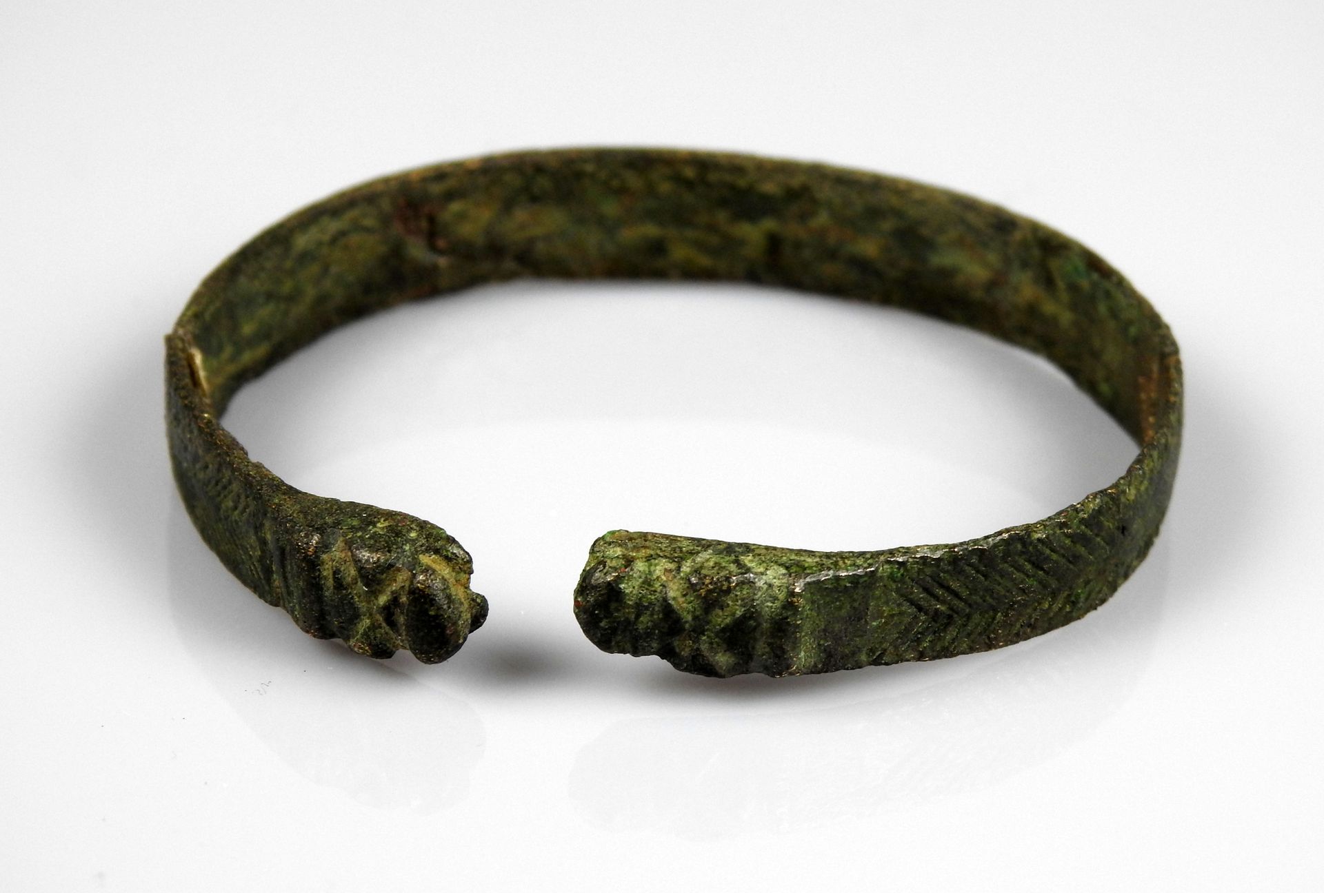 Null 以爬行动物头部为结尾的美丽手镯，装饰有Ocelli和Chevrons

青铜器6厘米旧修复

公元前一千年的原史