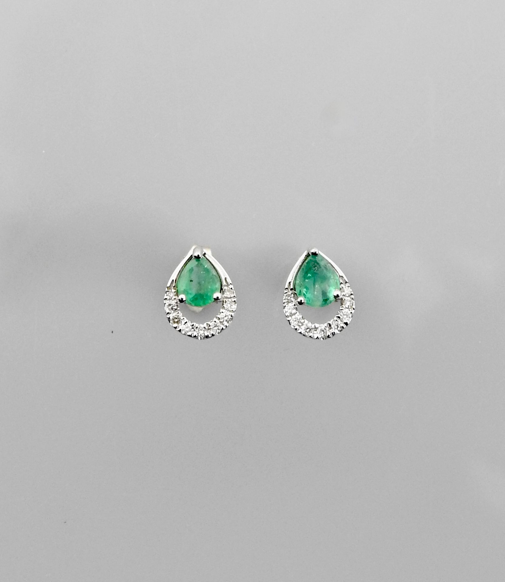 Null 白金耳环，750毫米，每只耳环都镶有一颗梨形切割的祖母绿，边缘镶有钻石，重量：1.35克，毛重。
