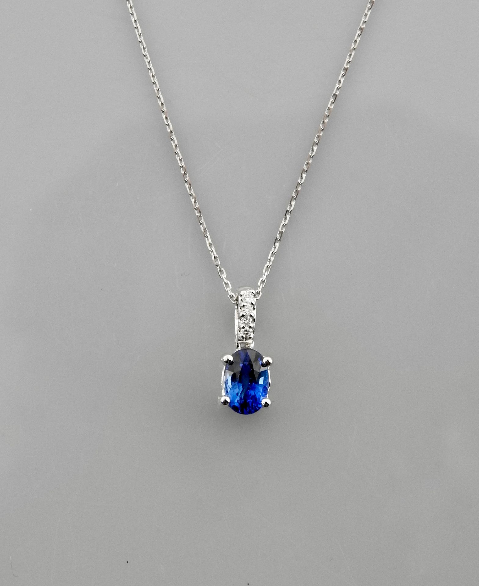 Null 750毫米白金链条和吊坠，镶嵌一颗重1.10克拉的椭圆形蓝宝石和四颗钻石，弹簧扣，长45厘米，重量：2.25克，毛重。