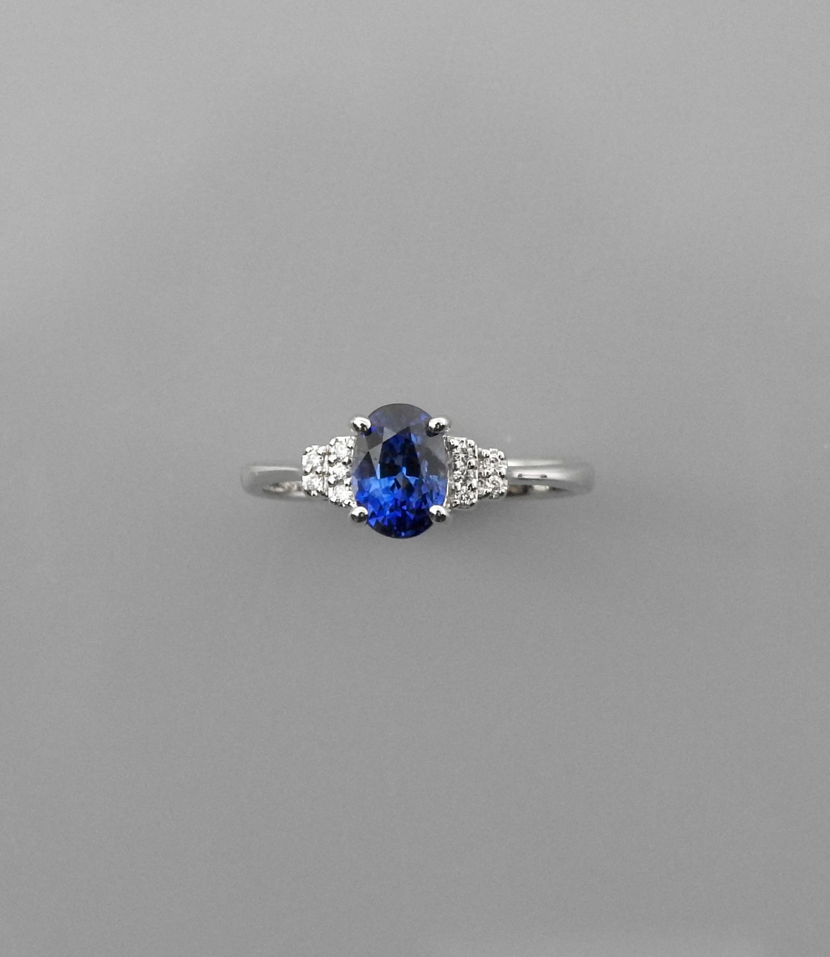 Null 白金戒指，750毫米，镶嵌一颗重1.65克拉的椭圆形蓝宝石，配以10颗钻石，11 x 7毫米，尺寸：54/55，重量：2.75克毛重。