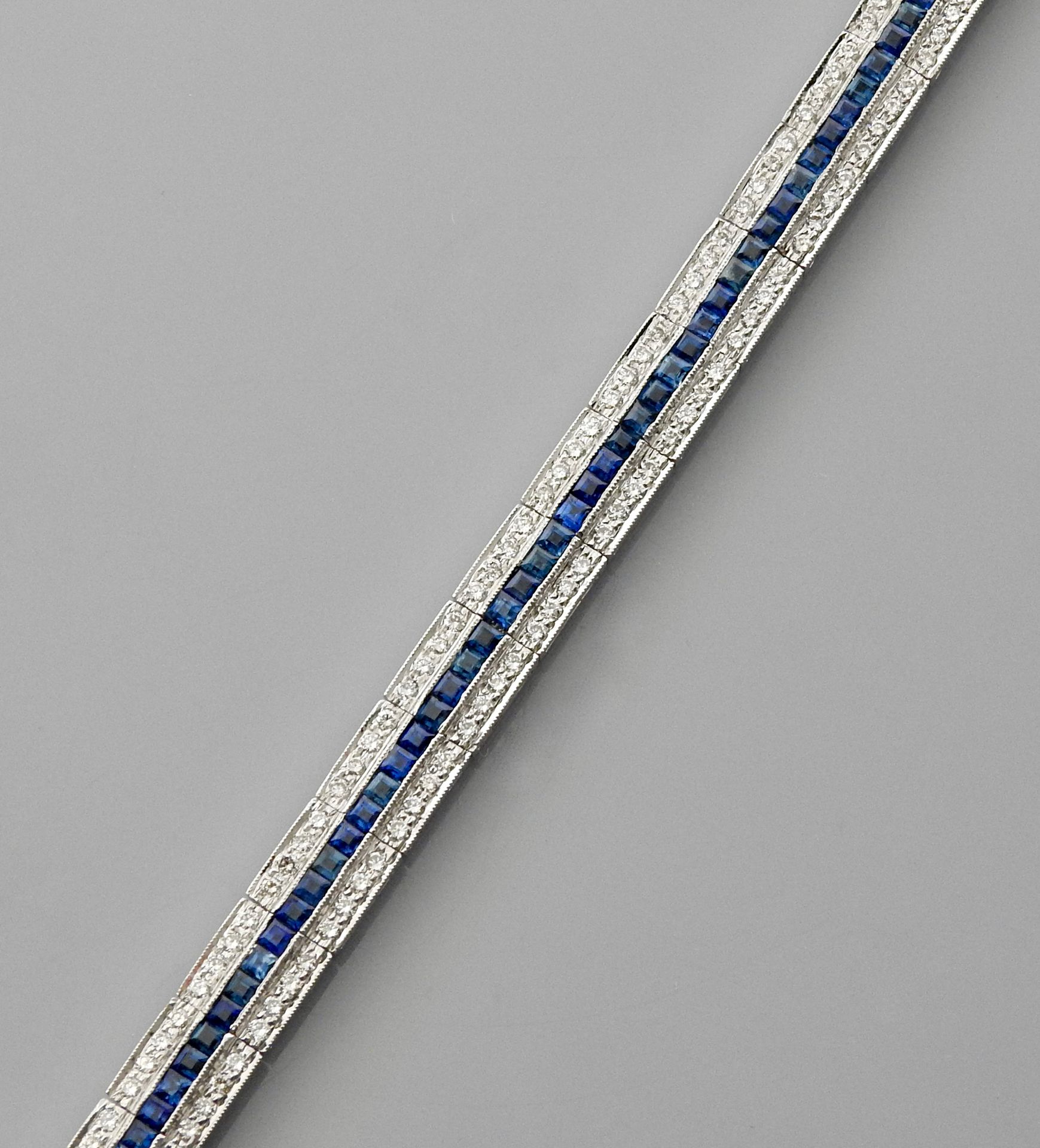 Null 白金铰链式手镯，750毫米，以一排蓝宝石为中心，在两排钻石之间，长18厘米，重量：23.16克，毛重。