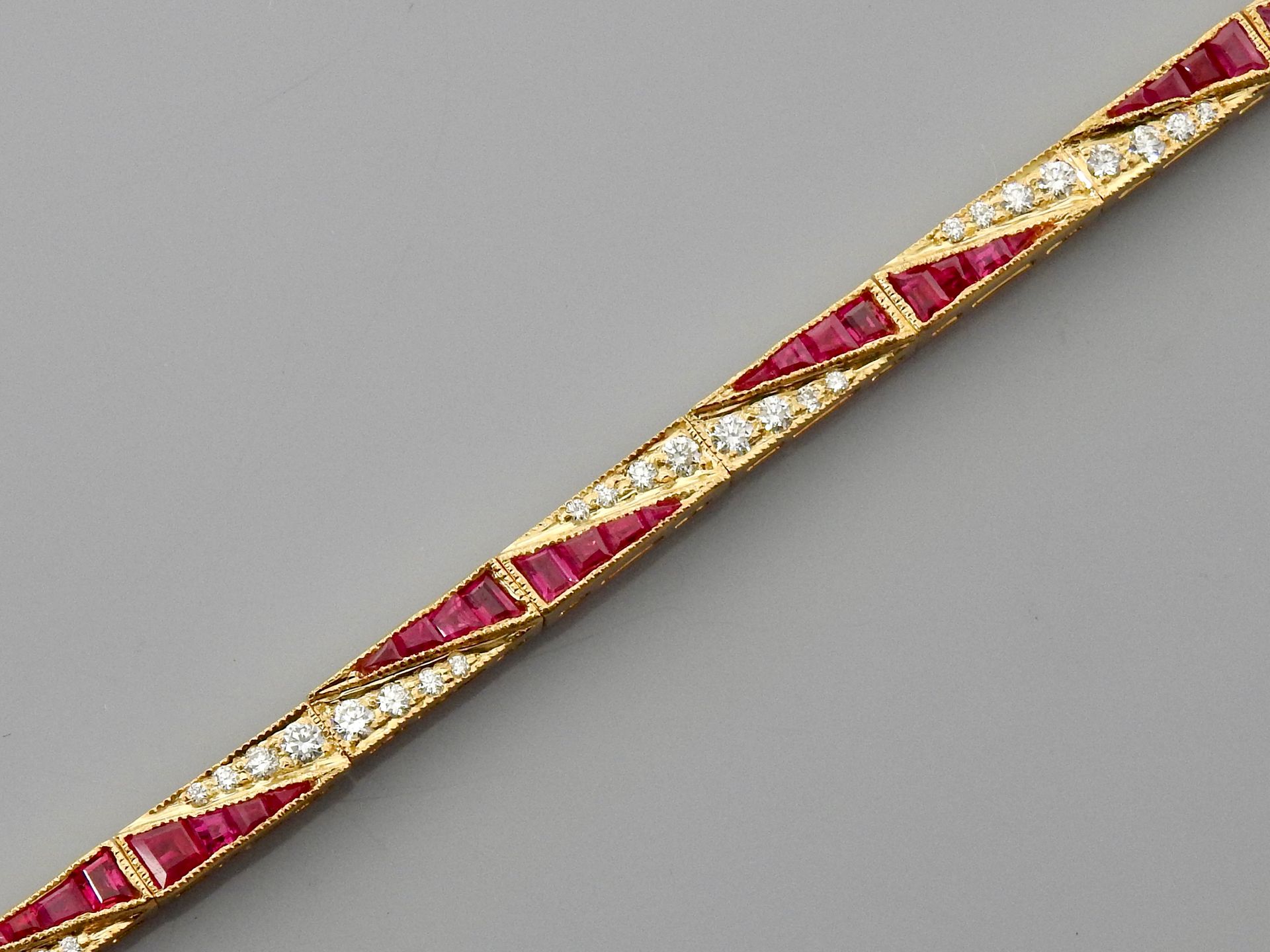 Null 黄金手镯，750毫米，由覆盖着切割红宝石的部分组成，总重约3克拉，钻石总重约1克拉，八个安全别针，长18厘米，重量：13.25克。