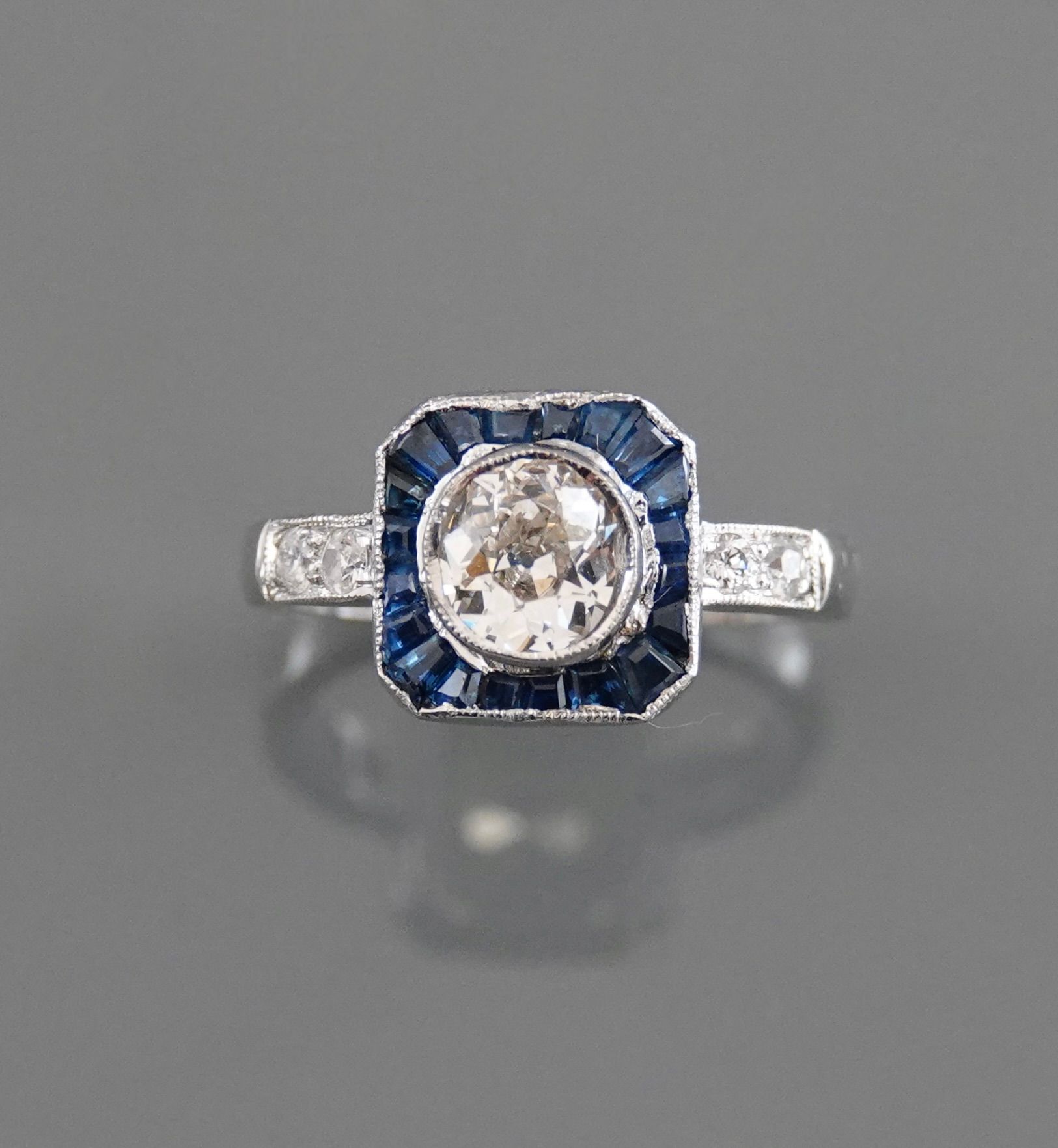 Null 黄金戒指，750毫米，以一颗重0.80克拉的钻石为中心，推定为J.VS，周围是校准的蓝宝石，两行钻石之间，边长1厘米，尺寸：53，重量：毛重5.74克&hellip;