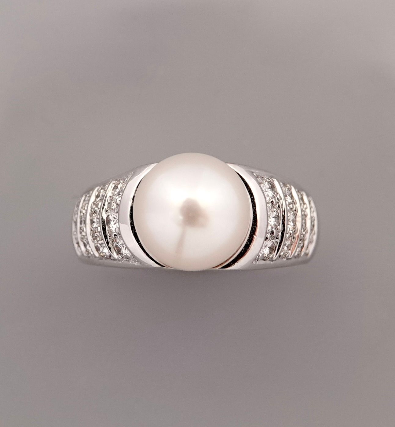 Null 白金戒指，750毫米，以一颗直径为10毫米的养殖珍珠为中心，在两颗钻石的铺垫下，加入内金以稳定其在手指上的位置，尺寸：55，重量：11.17克，毛重。