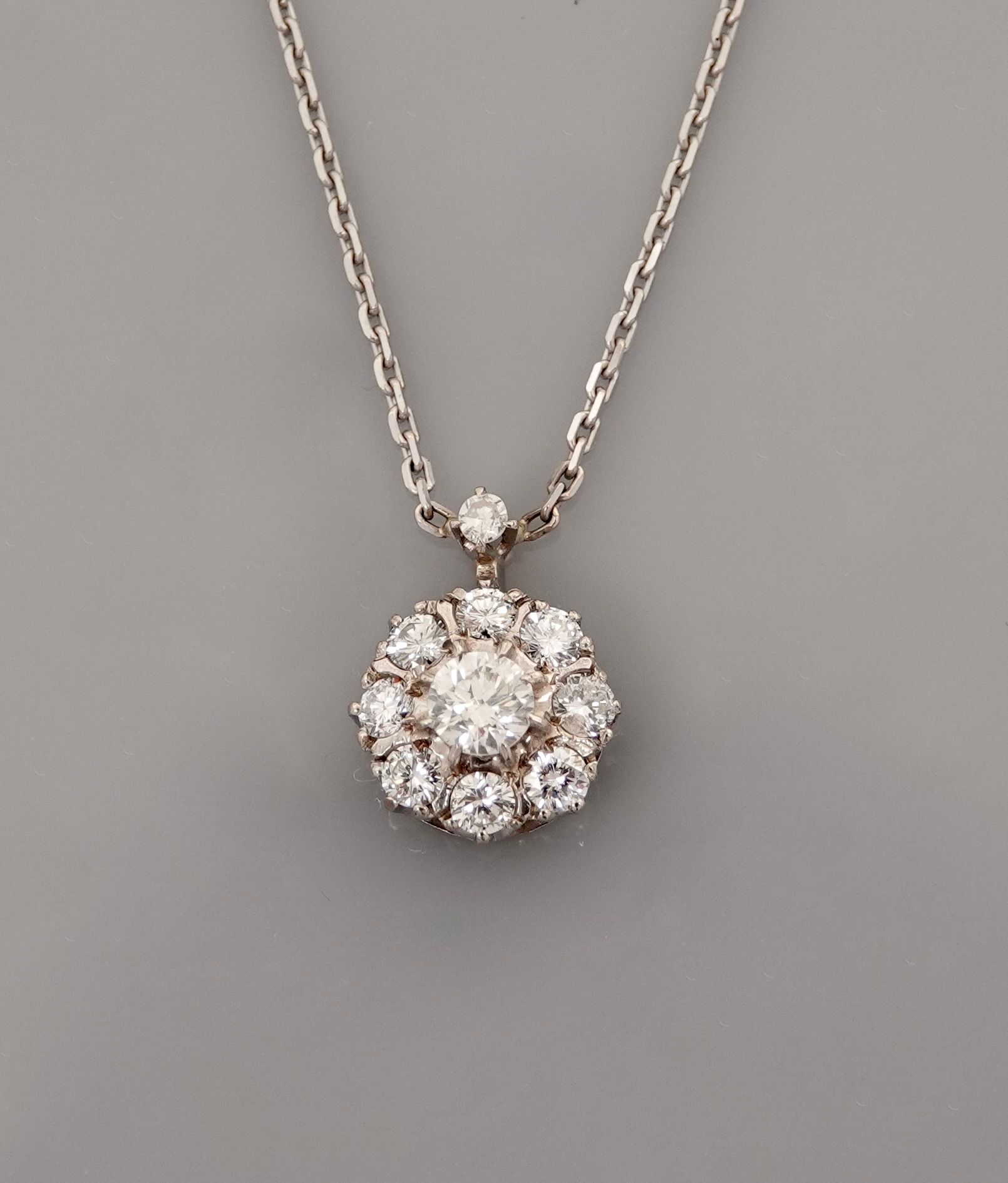 Null 白金链条和吊坠，750毫米，形成一个圆形的百合花，中心是一排总重约0.80克拉的钻石，扣子上有一颗钻石，长42厘米，重量：毛重3.7克。