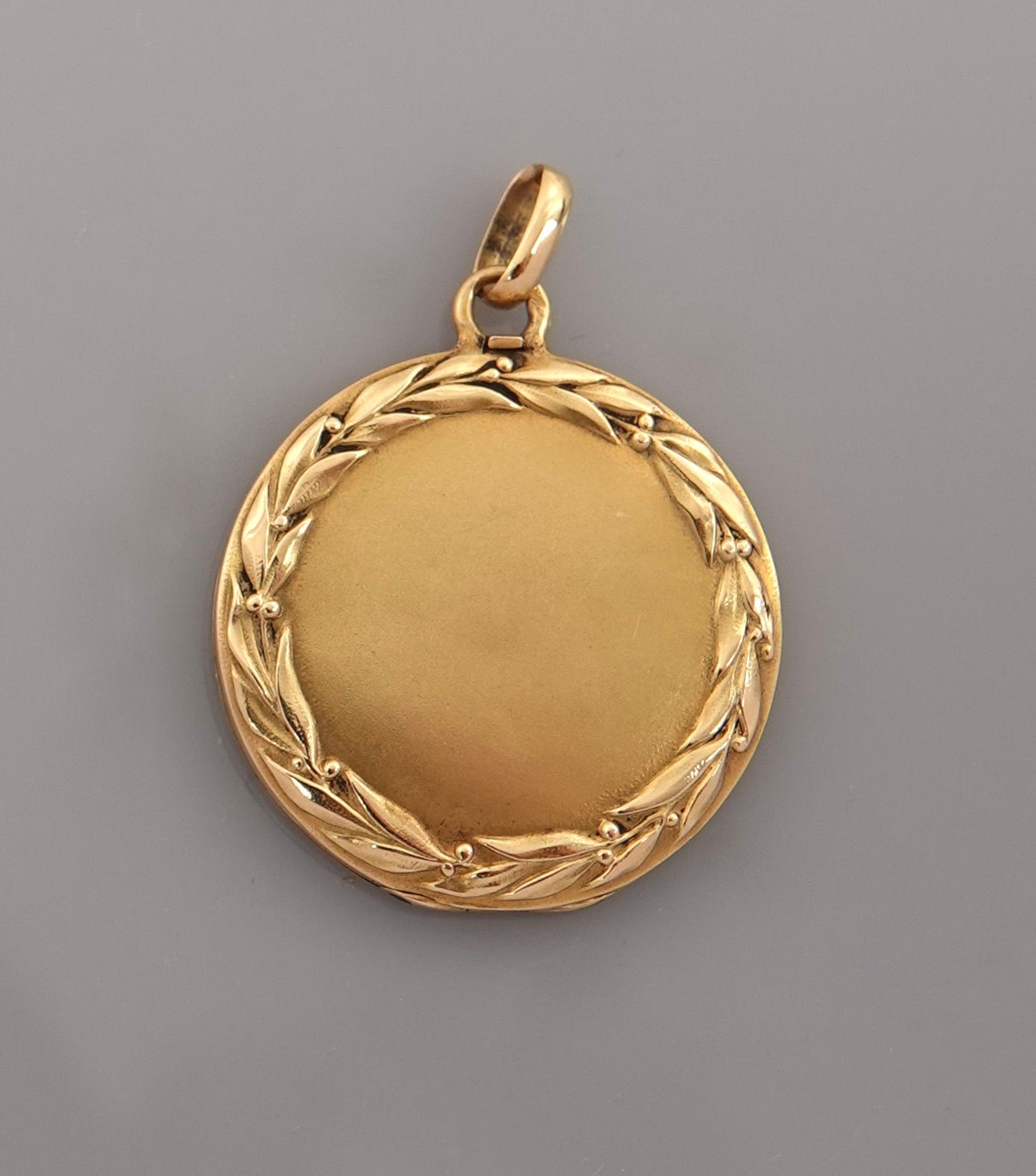 Null 圆形奖章，黄金材质的开口 "照片架"，750毫米，有叶状装饰，直径24毫米，约1900年，重量：4.8克，毛重。
