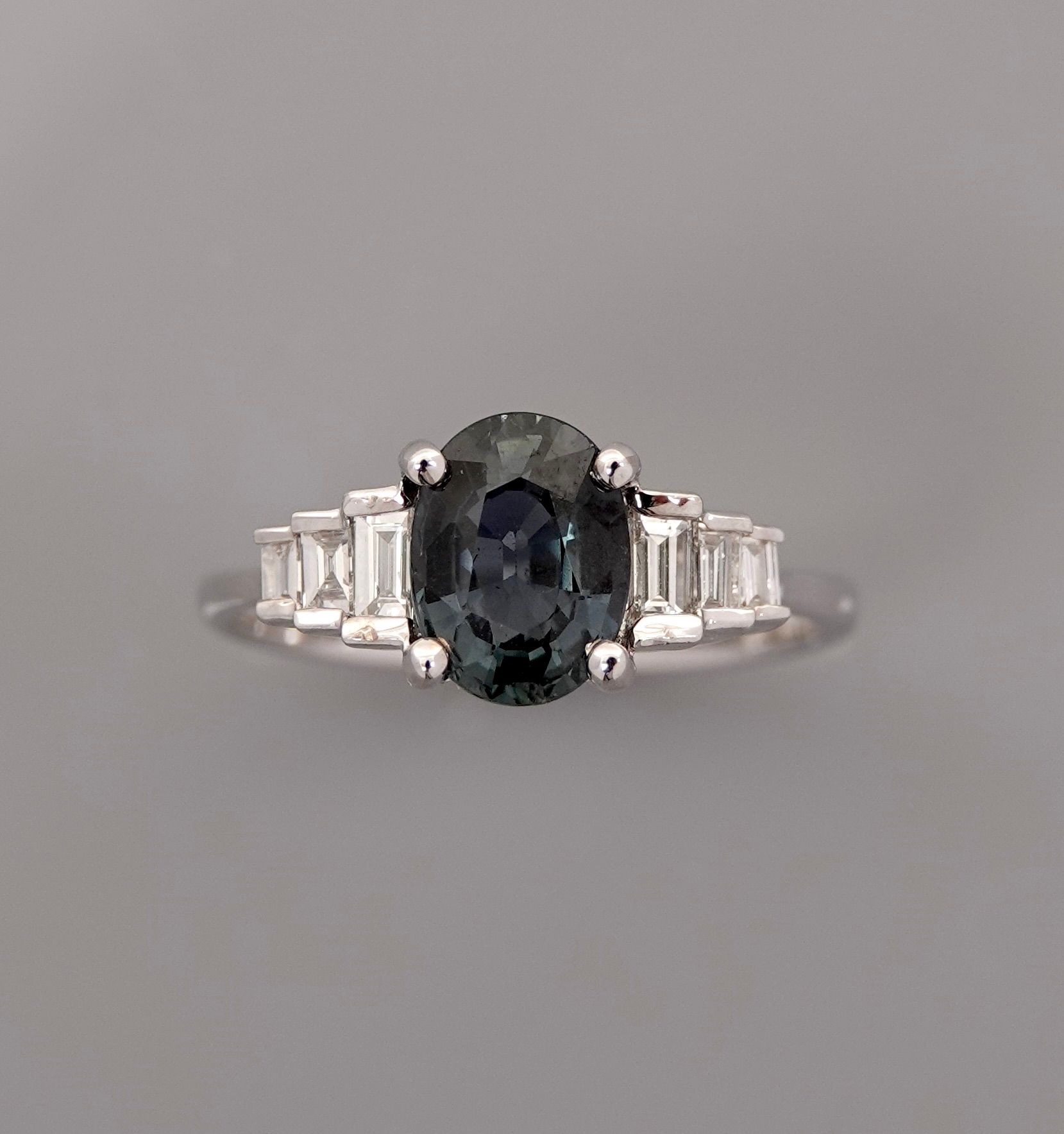 Null 白金戒指，750毫米，镶嵌一颗重达1.70克拉的椭圆形绿色蓝宝石，以及六颗长方形切割钻石，尺寸：53/55，重量：3.1克，毛重。
