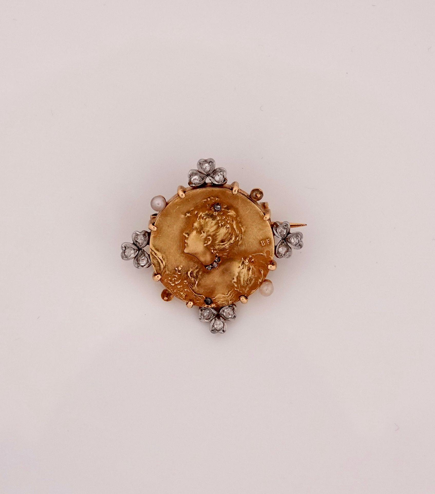 Null 新艺术运动。黄金圆形胸针，750毫米，画了一个女人的轮廓，半身装饰着珠宝，周围是玫瑰和珍珠种子，直径2厘米，有B.F.的字样，约1900年，重量：9.&hellip;