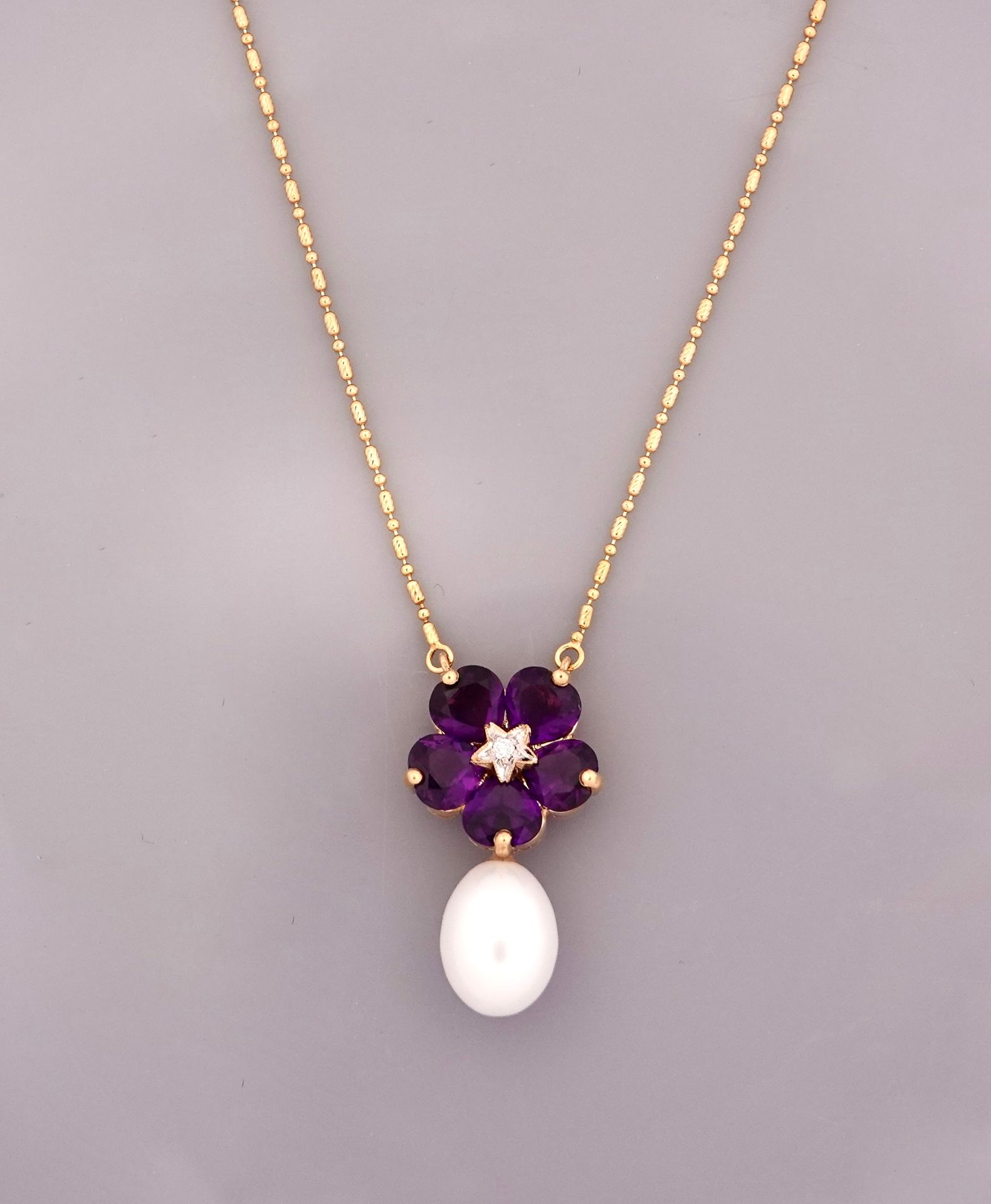 Null 黄金橄榄形项链，750毫米，中心是总重约4.80克拉的紫水晶，周围有一颗钻石，并带有一颗坠落的珍珠，长43厘米，重量：9.35克，毛重。