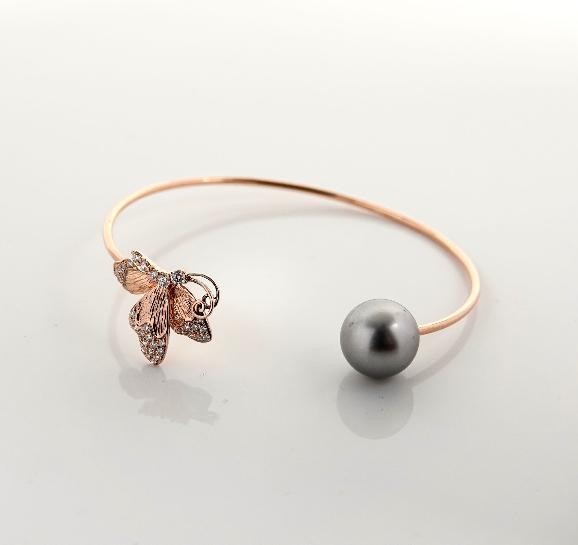 Null 玫瑰金镂空手镯，750毫米，镶嵌一颗直径为10毫米的大溪地珍珠，面对一只飞舞的蝴蝶，上面镶有钻石，重量：7.2克。