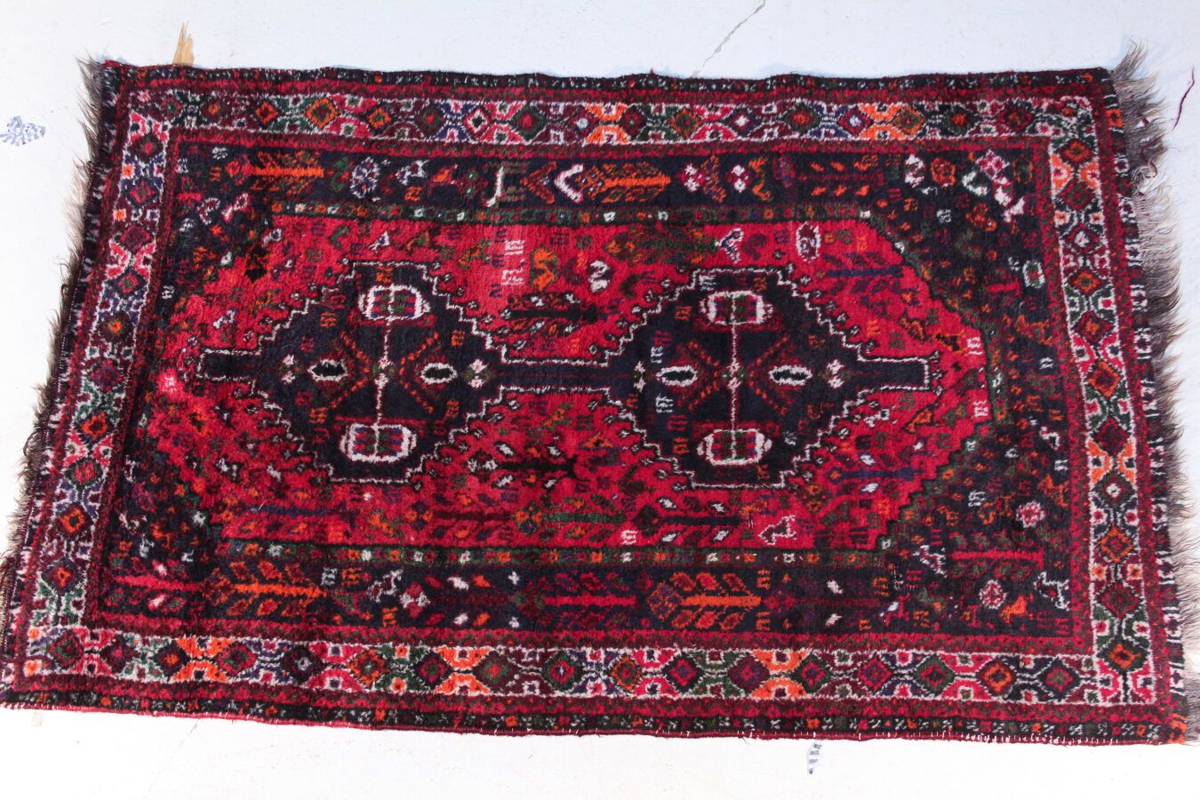 Null Woolen carpet with knotted points and geometric decoration on a red backgro&hellip;