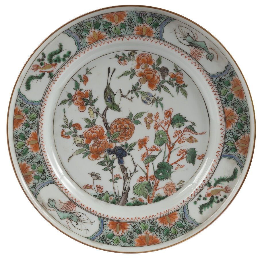 Null 绿色家族瓷盘一对

中国，18世纪

中央饰有一只栖息在牡丹茎上的鸟，翅膀上饰有鱼和虾，背景为花。

D.: 22,5 cm

(底座下的芯片)