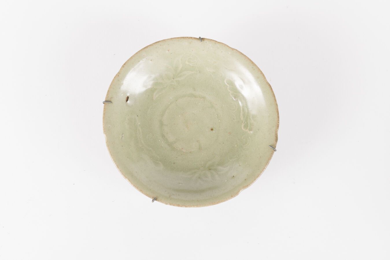 Null 三件青瓷釉面石碗和一个碗
越南和中国，14/15世纪 
饰有花卉图案，其中两件有弯曲的边缘；有缺口，珐琅质的缺口和裂缝
直径：16和17.5厘米