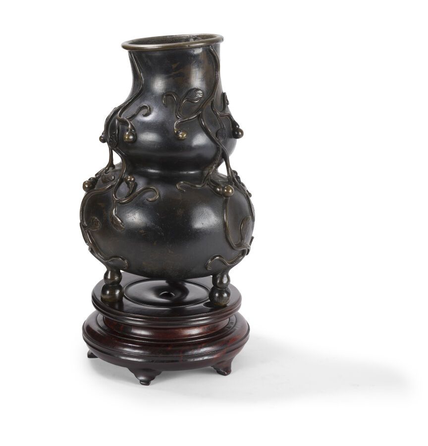 Null 青铜三足鼎立的双葫芦花瓶
中国，19世纪 
站在三个小脚上，身体上有轻浮的葫芦装饰，木质底座；铸造缺陷
H.30厘米 

狀況報告:
中间有铸造缺陷