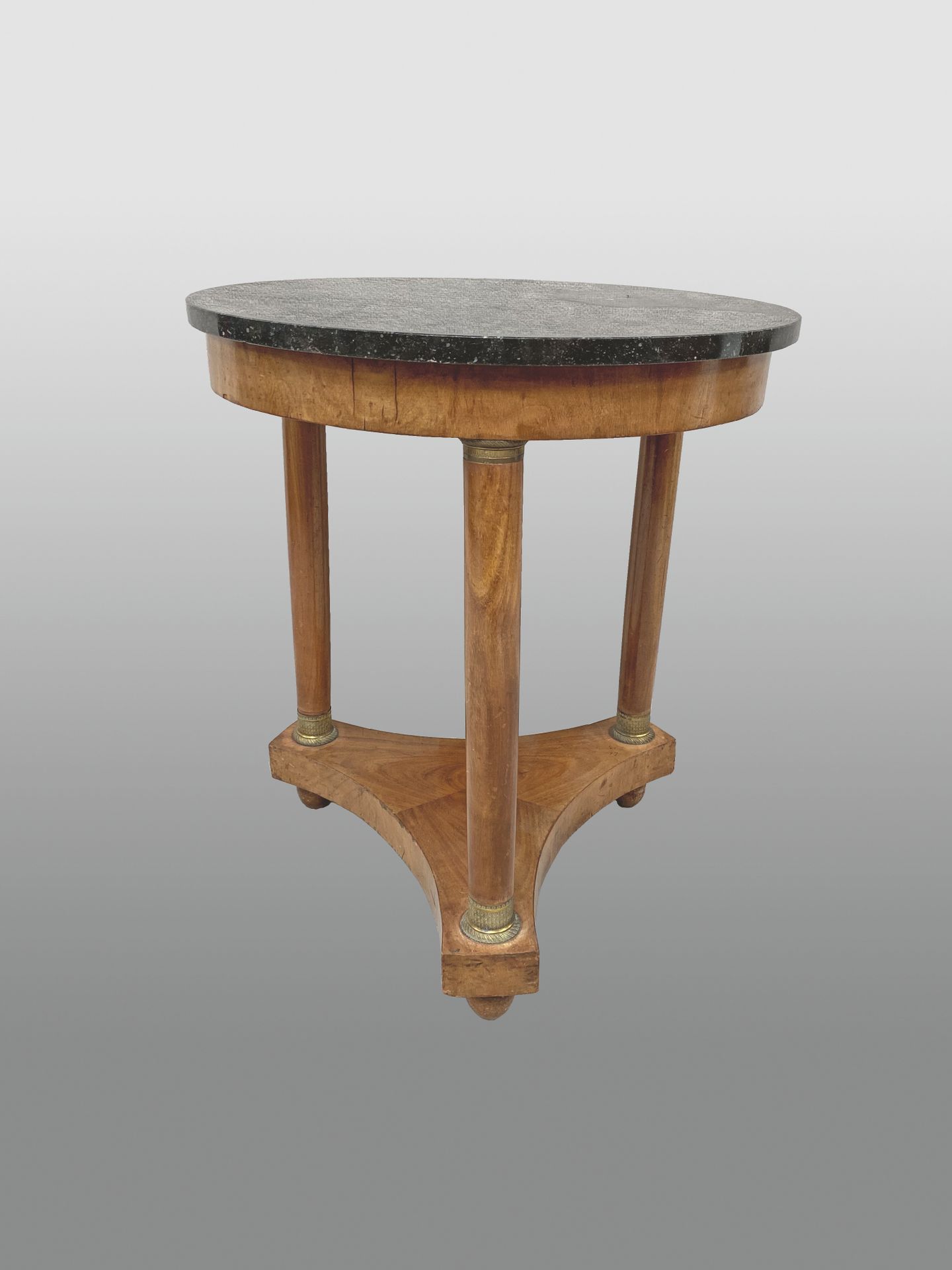 Null 圆形桃花心木和桃花心木饰面的基座桌，放在由支架连接的三根柱子上。黑色大理石顶部。

帝国时期。

高：70厘米 - 深：60厘米