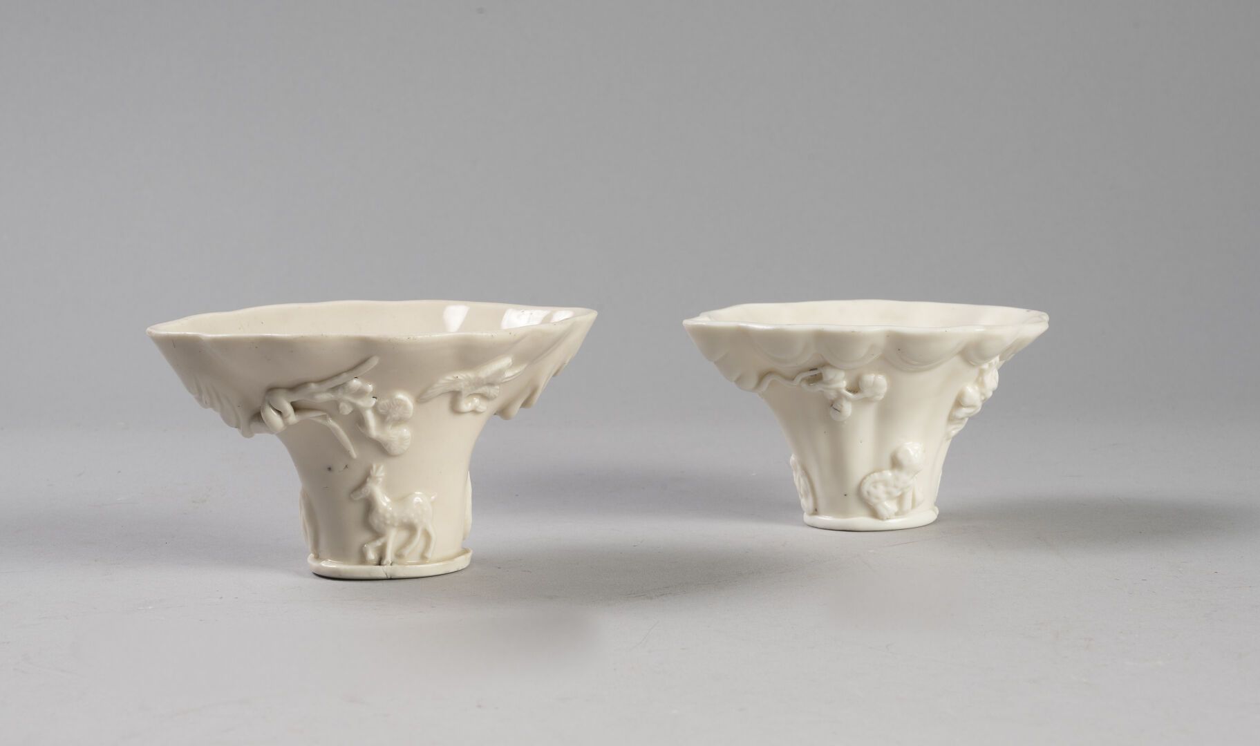 Null 中国

两个酒杯

中国白瓷，饰有龙、鹿和花的图案

康熙时期，18世纪

高度为7和8厘米

(烧制过程中出现一些小裂纹，其中一个的底部有一个缺口)