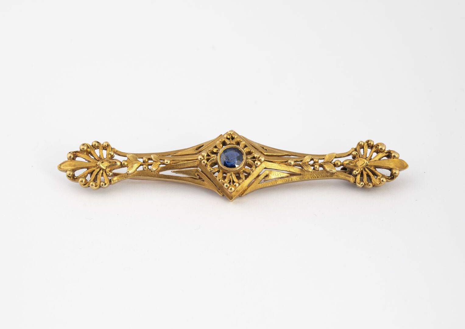 Null 发夹式胸针

在750°/°金中

镶嵌着一颗蓝宝石，并有棕榈花纹装饰。

约1900年。

毛重 : 9,89 g