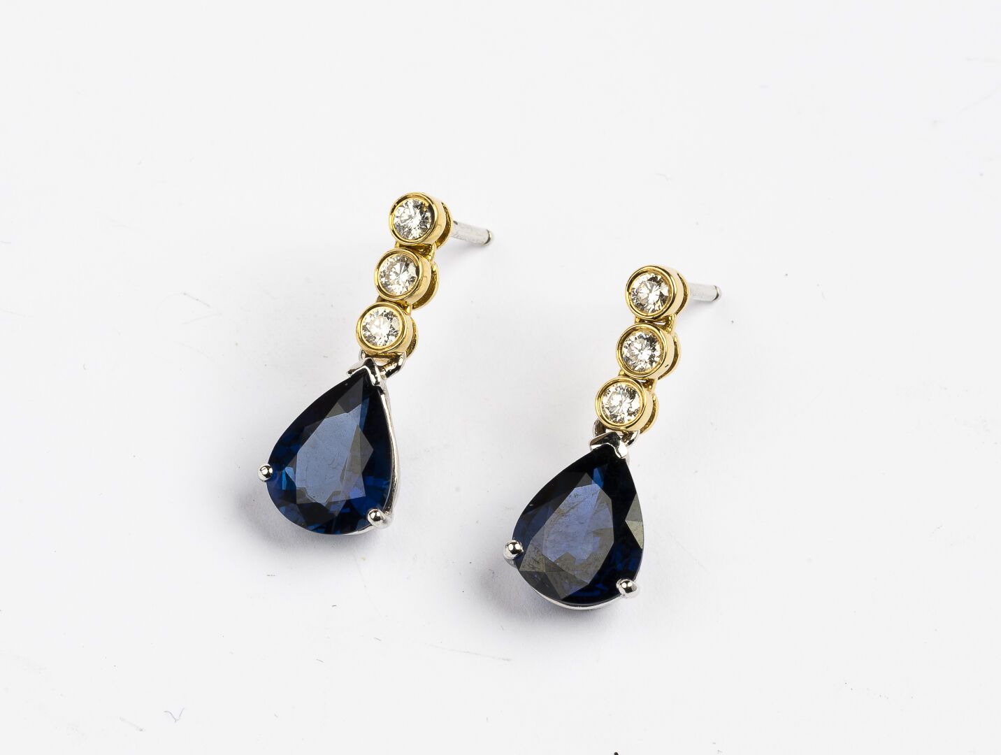 Null 耳环一对

两个750°/°的黄金

镶嵌一排三颗钻石，托着一颗约2.50克拉的梨形蓝宝石。

毛重：5克