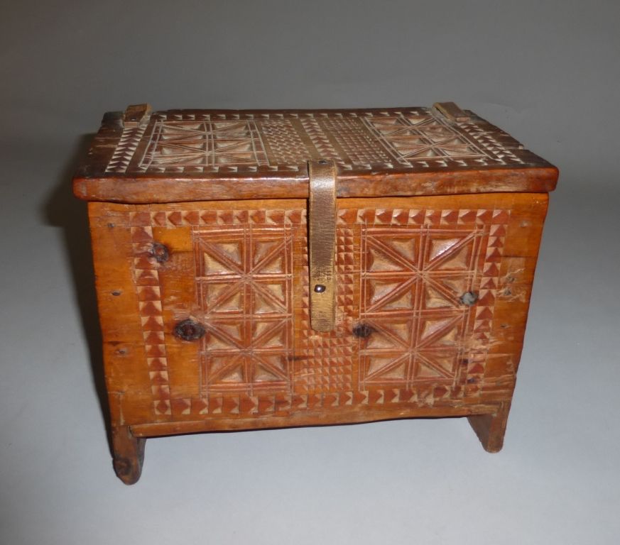 Null 雕刻的木制花边盒，四面都有方块和楣条的装饰。盒盖由皮革带子固定。
民间艺术，维莱，19世纪末。
H.22 W. 27.5 D. 17 cm