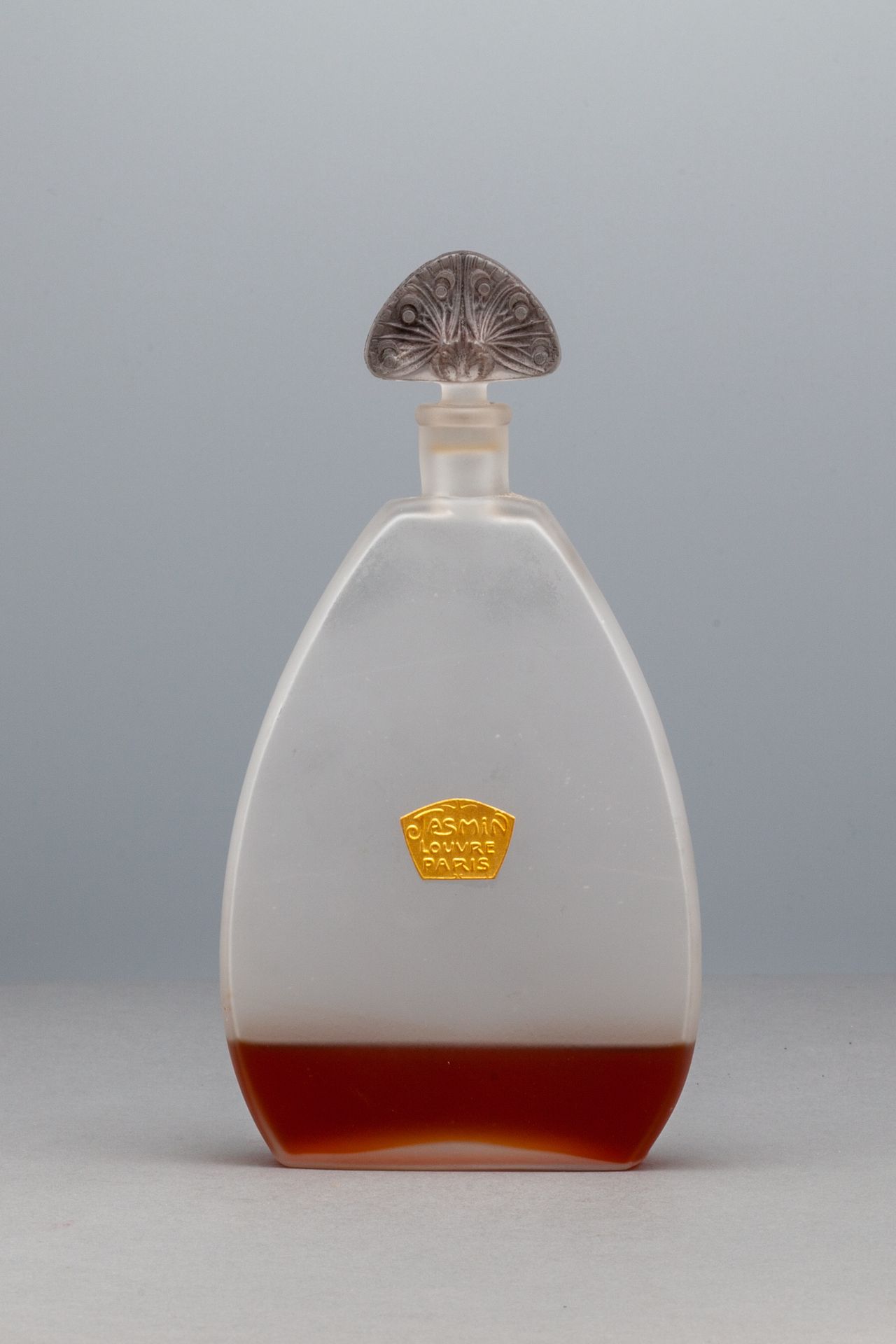 MAGASIN DU LOUVRE "JASMIN" 乳白色的玻璃瓶。在中央，有一个镀金和标题的标签。瓶塞上有格子花的装饰。高18,8厘米