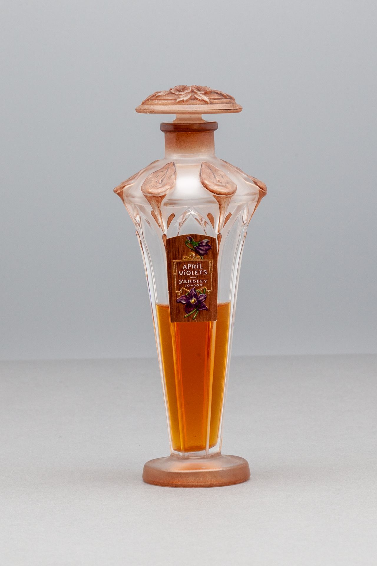 YARDLEY "APRIL VIOLETS" 喇叭形的玻璃瓶，瓶盖上有花纹装饰。标签名为：。