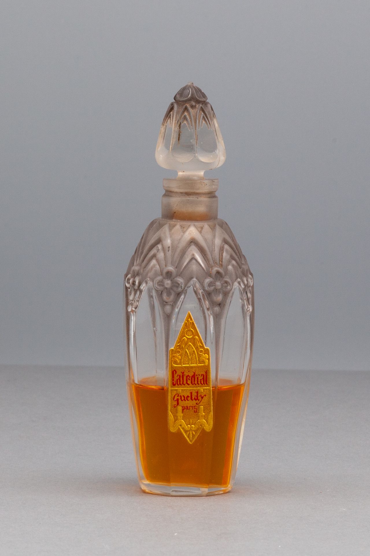 GUELDY "CATEDRAL" 橄榄形玻璃瓶，有花朵装饰。镀金和标题的标签。瓶塞上装饰着风格化的花朵。
