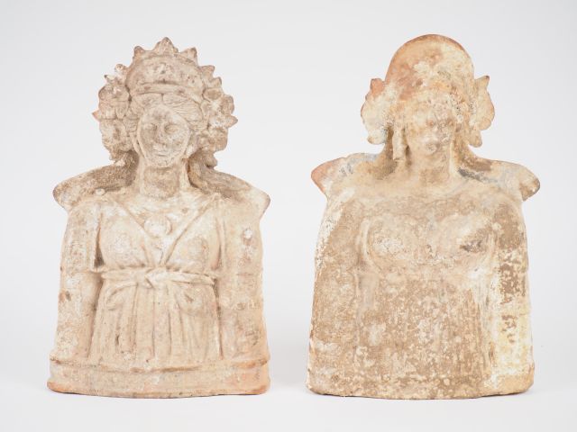 Null 两件大型女性赤土半身像（供奉神灵：德墨忒尔、科雷、阿尔特弥斯或阿佛洛狄忒），身穿胸前系着的外衣，戴着花冠。椅背的顶部出现在肩部后面。每个头后面都有一个&hellip;