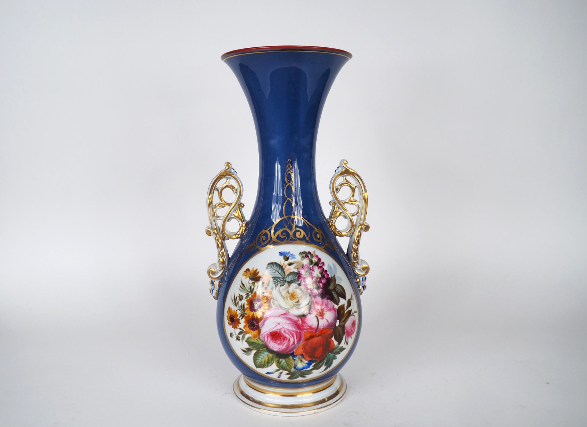 Null 一个拿破仑三世的带柄瓷瓶，以蓝底多色花为储备装饰，辅以金色，镂空手柄。

H.44.5厘米。