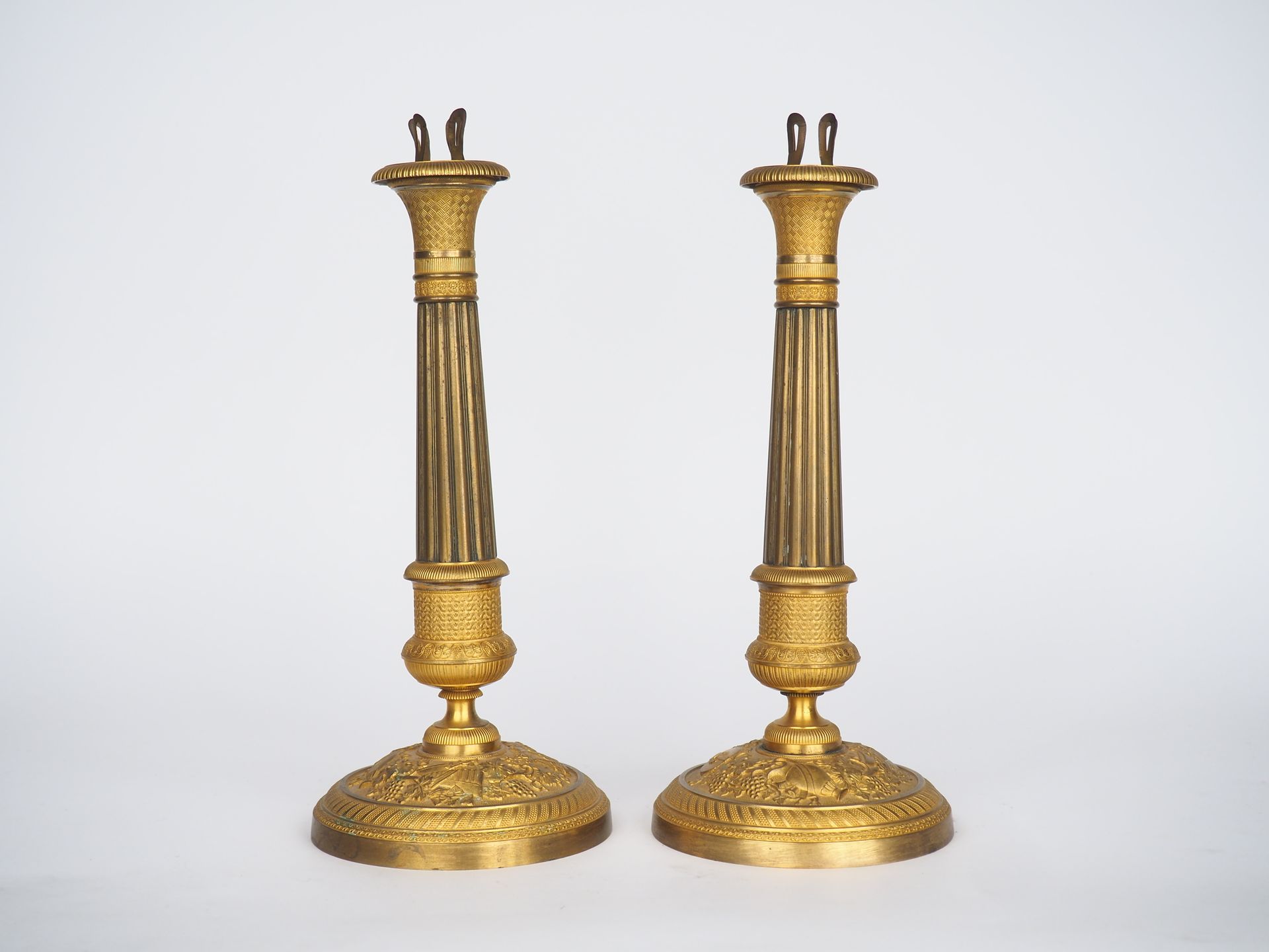 Null 一对修复时期的鎏金青铜和黄铜烛台，装饰有笛子、奖杯、帕姆、叶子和花。

H.29,5厘米。