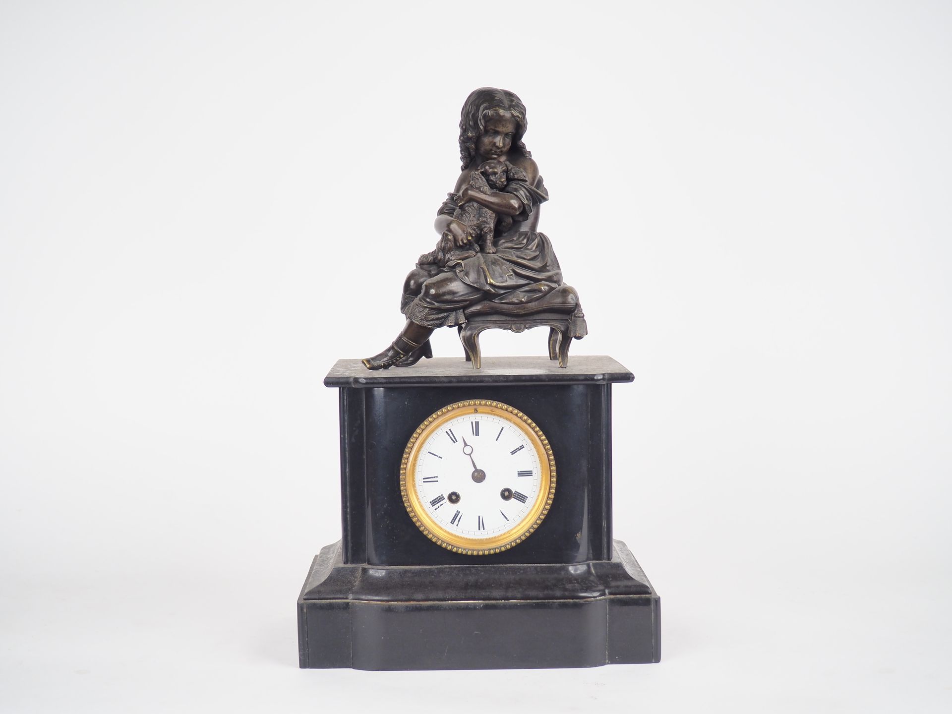 Null 一个拿破仑三世的黑色大理石和青铜钟，带有棕色的铜锈 "带小狗的年轻女孩"。 搪瓷表盘。

尺寸：42 x 25,5 x 17,5厘米。

(缺少一根针&hellip;