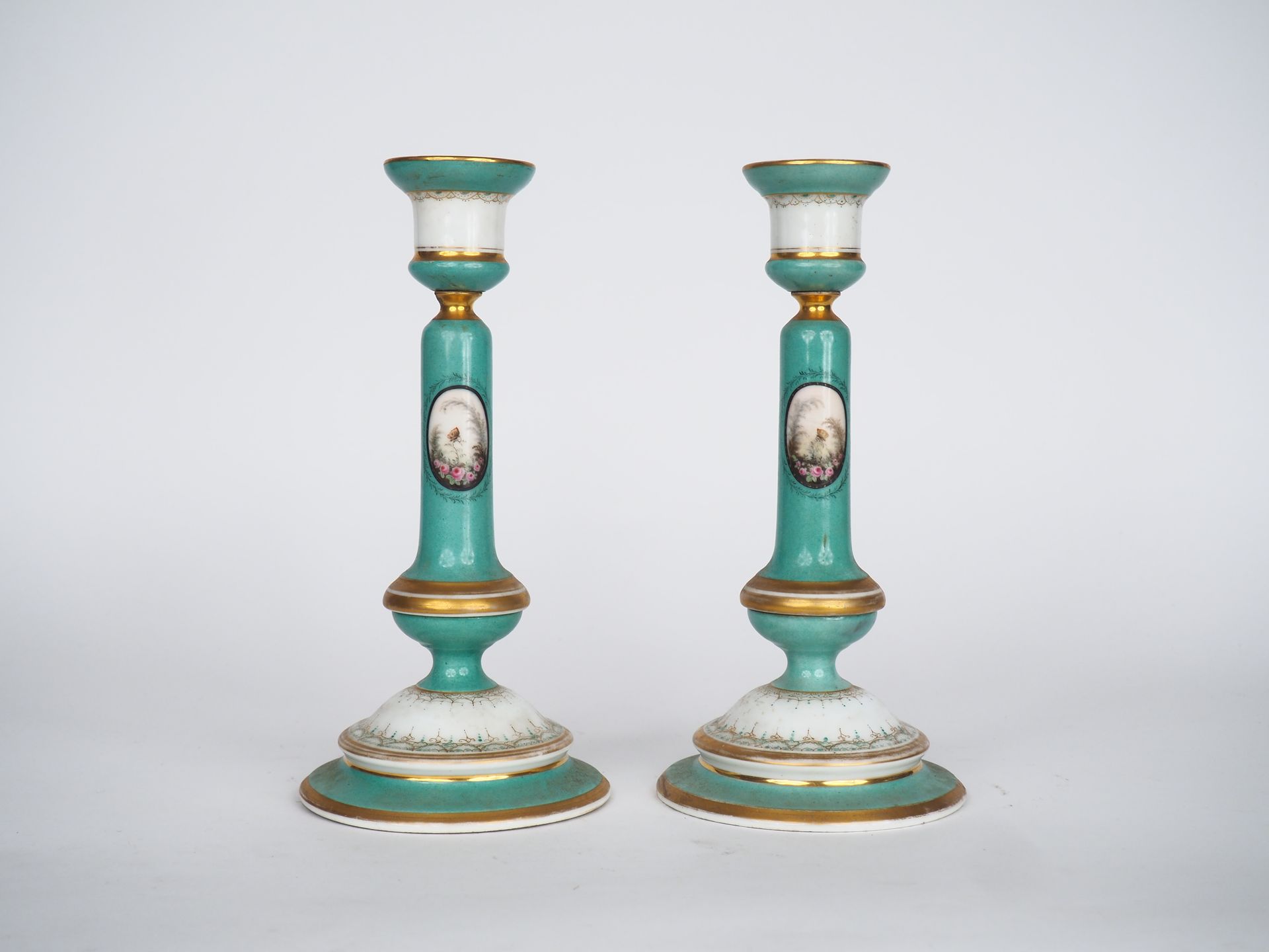 Null 一对拿破仑三世的多色瓷器烛台，在绿色和白色的背景上装饰有蝴蝶的储备，卷轴和金色的边框。

尺寸为25 x 12厘米。