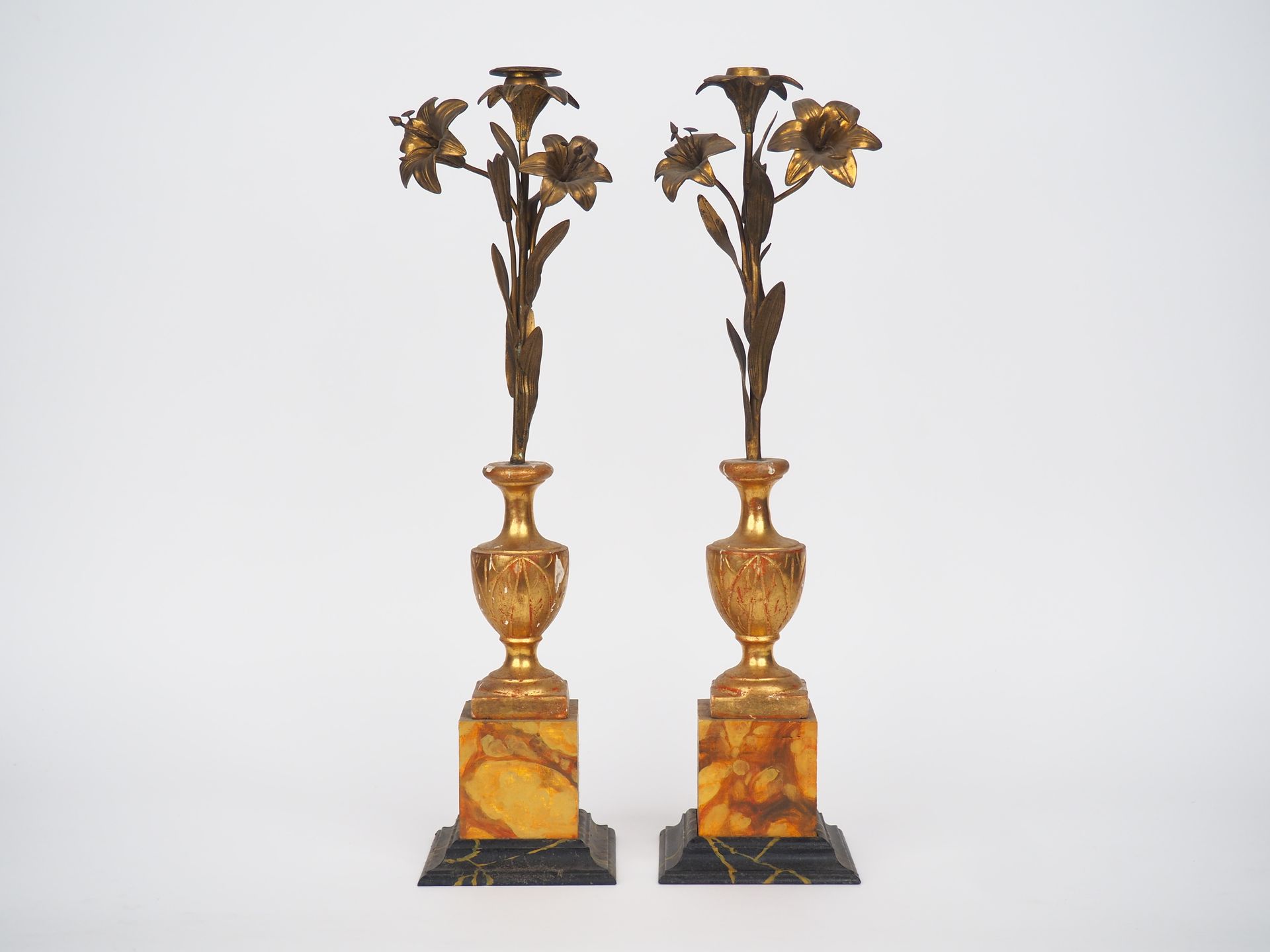 Null 一对19世纪的鎏金木和黄铜烛台，形式是三朵百合花，有一个仿大理石的底座。

H.51,5厘米。

(镀金痕迹)。