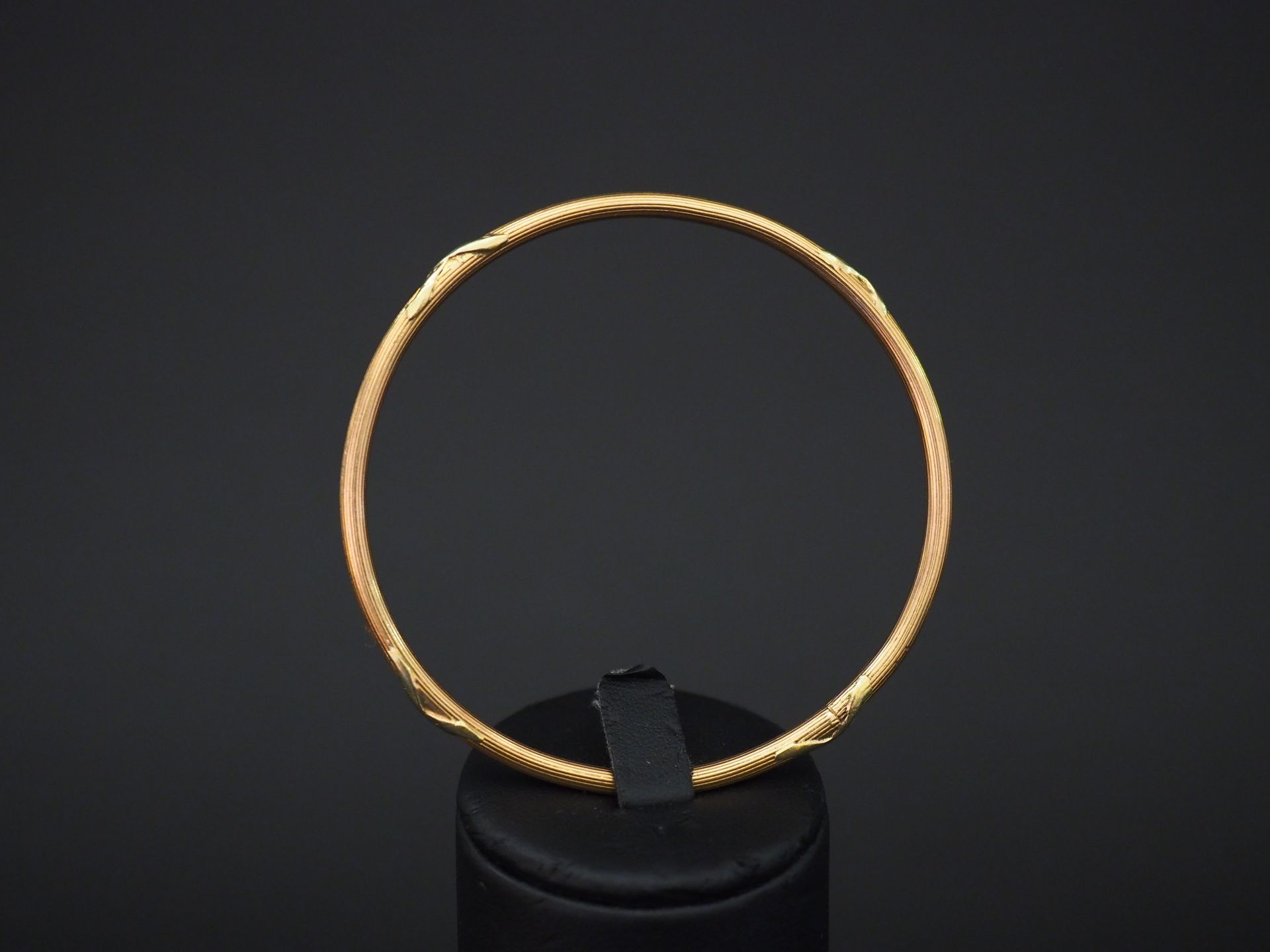 Null Bracelet jonc en or jaune, à décor de tiges enrubannées.

Diam. 6,1 cm

Poi&hellip;