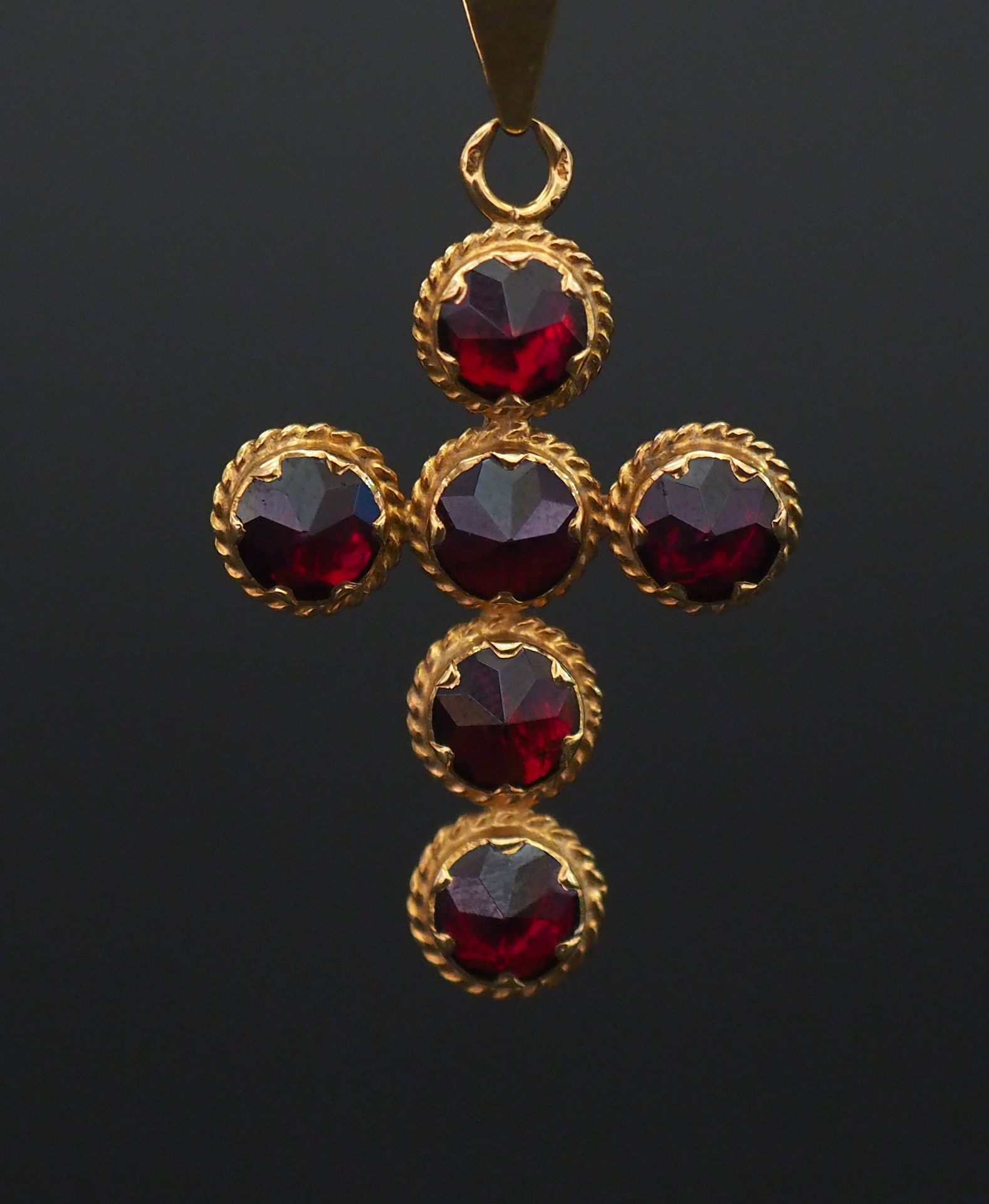 Null Yellow gold pendant in the shape of a cross, set with six garnets.

3,4 x 2&hellip;
