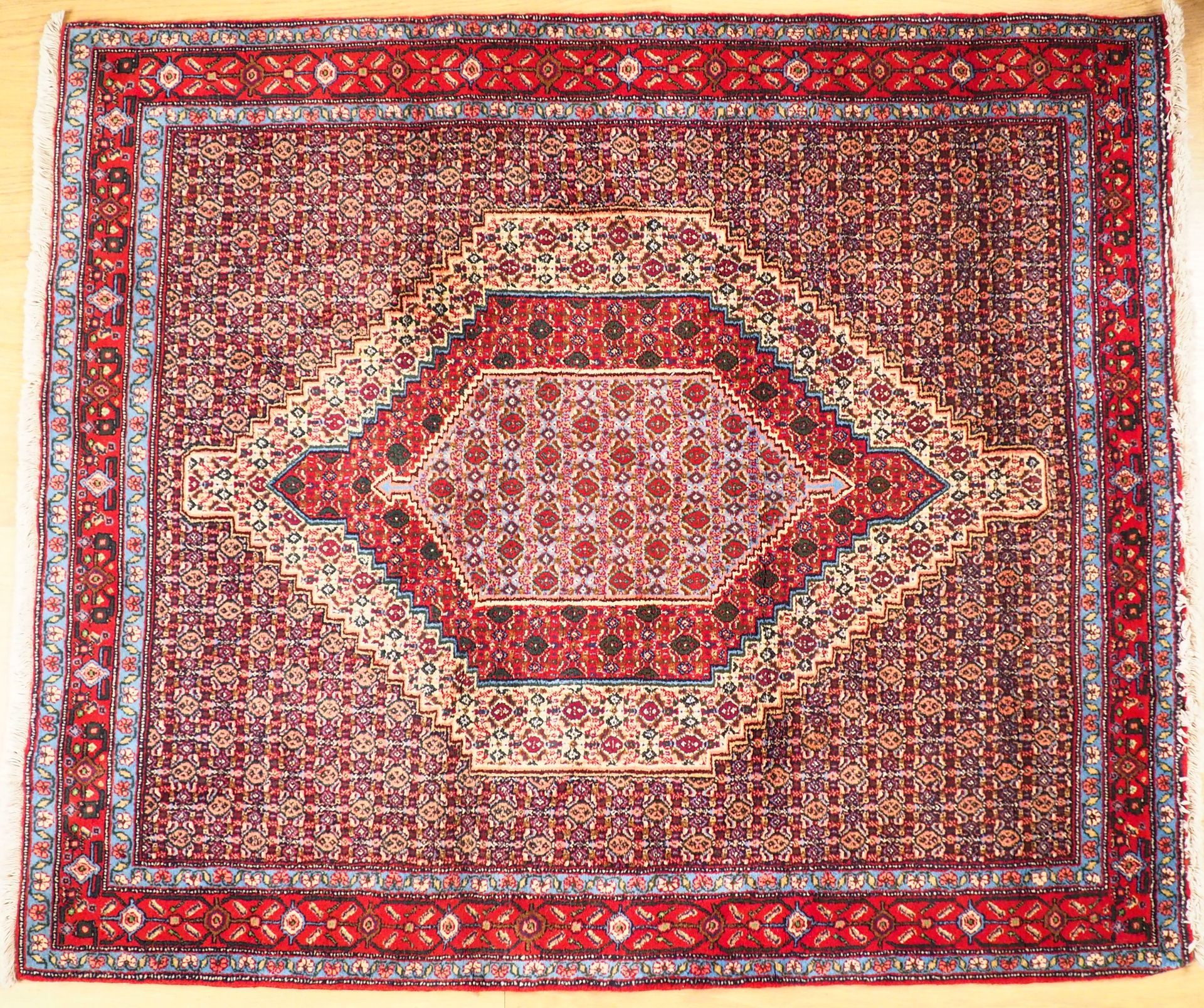 Null 羊毛祈祷毯，在红色背景上装饰有几何图案和楣条。

尺寸144 x 124厘米