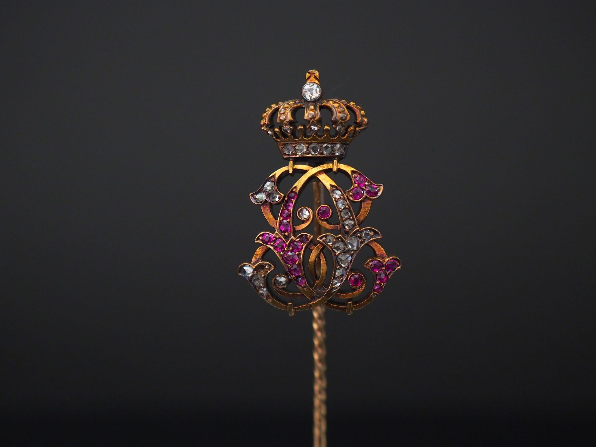 Null 黄金领带针，上面有字母和皇冠，上面镶嵌着小钻石和粉色宝石。

图案尺寸：2.9 x 2 cm

H.7,5 cm

重量：6.33克