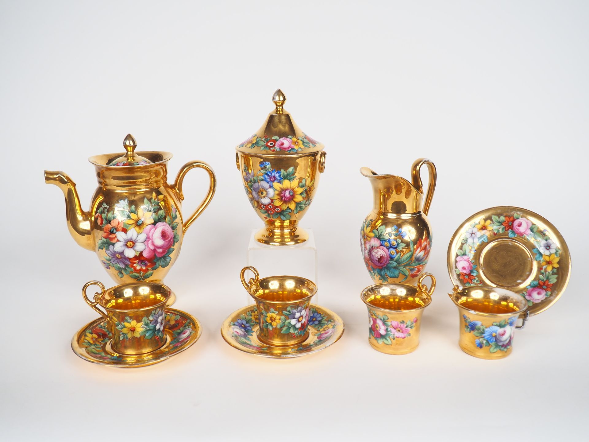 Null 
19世纪末的巴黎瓷器咖啡套装，装饰有镀金背景的花束和多色花环，包括：3个异形件，4个杯子和3个茶碟。 




(一个手柄断裂)