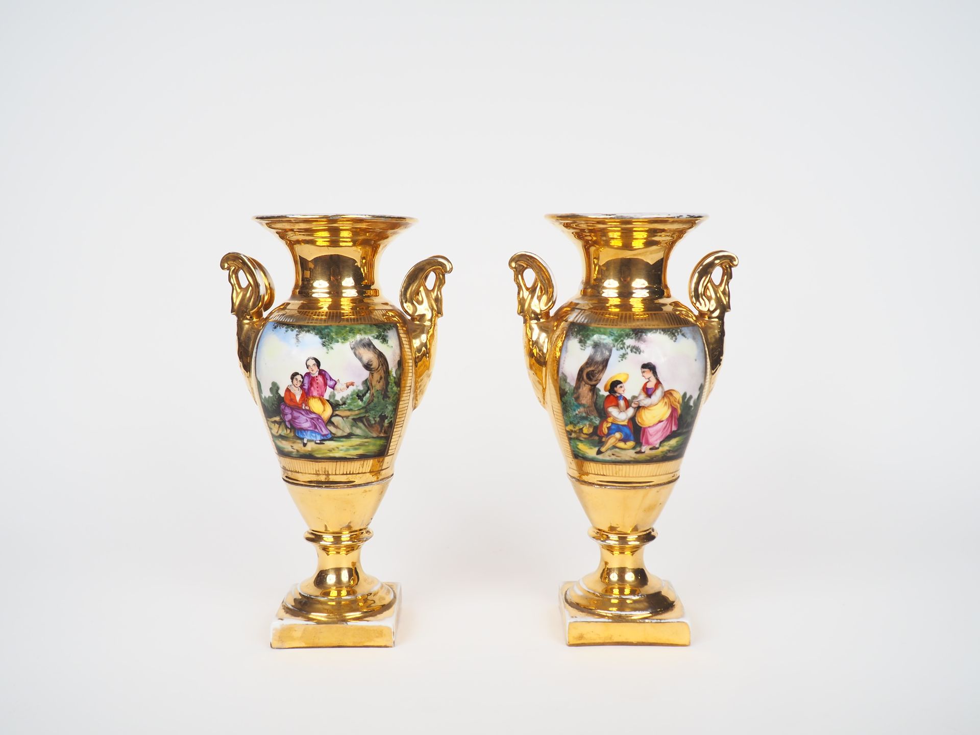 Null 一对来自巴黎的修复时期的瓷器花瓶，在完全鎏金和雕刻的背景上装饰着英勇的场景，天鹅把手。

H.29厘米