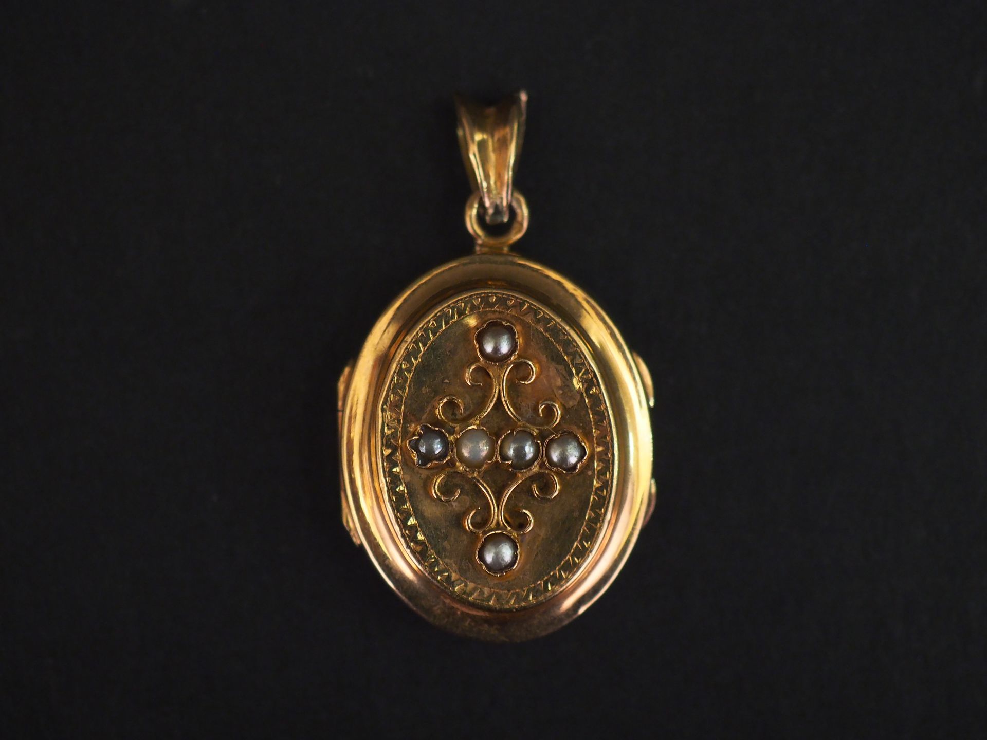 Null 一件拿破仑三世的黄金吊坠，带有丝状装饰，并镶嵌有小珍珠。

高度：2.6厘米（不含搭扣

重量如故。3,73 g

(玻璃缺失，非常轻微的凹陷)