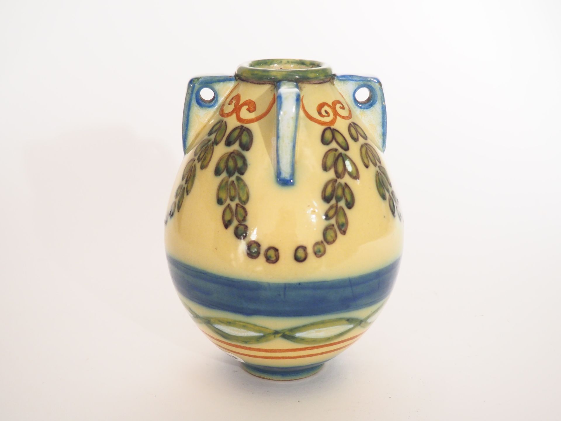 Null Henri PARAYRE.
一个多色陶器花瓶，有四个把手，上面装饰着黄蓝背景的花环。
H.18厘米。