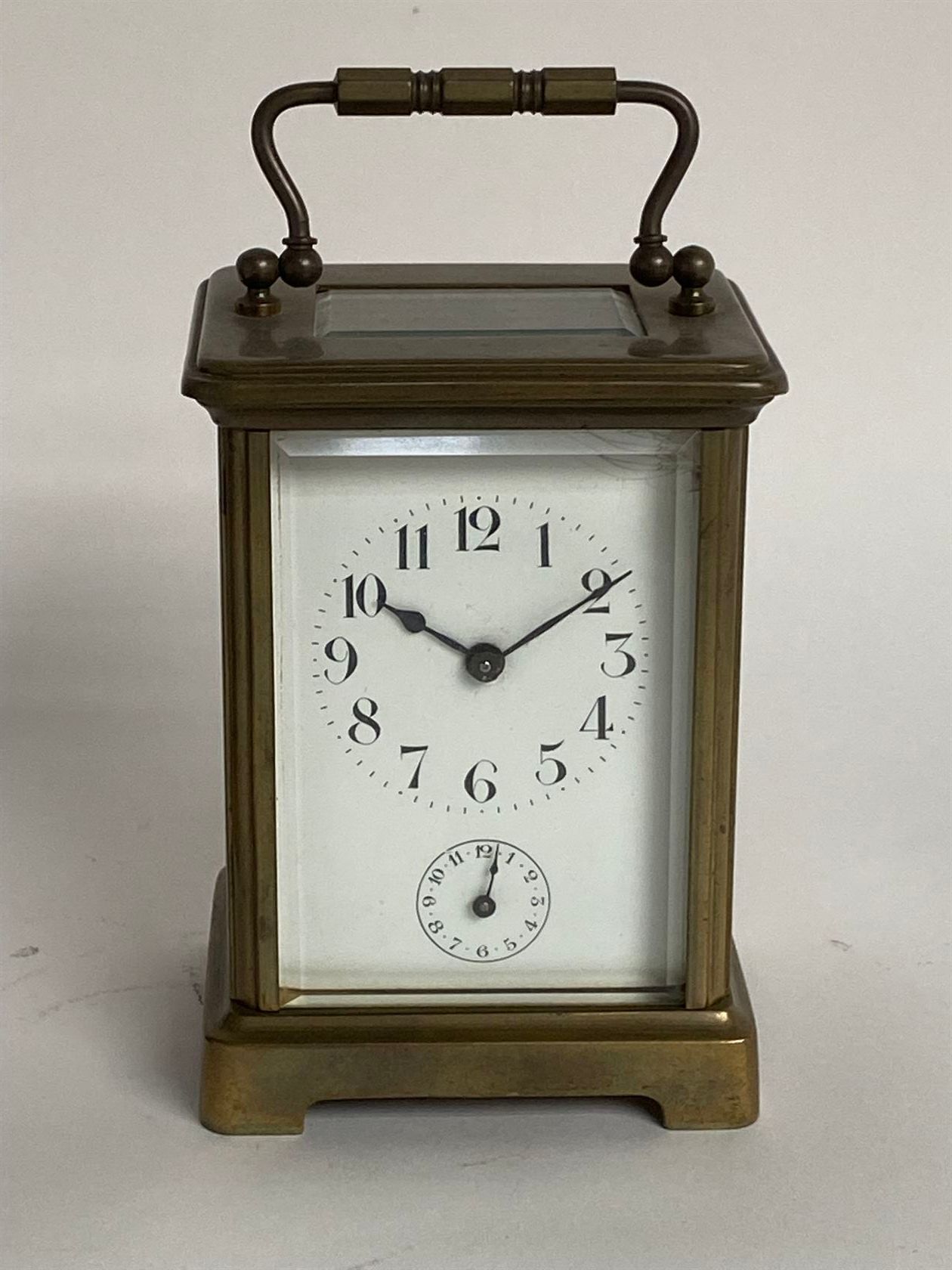Null 黄铜笼式框架的军官钟，斜面玻璃，阿拉伯数字和秒针，可拆卸的把手，配有钥匙。约1900年。高11.1厘米。
