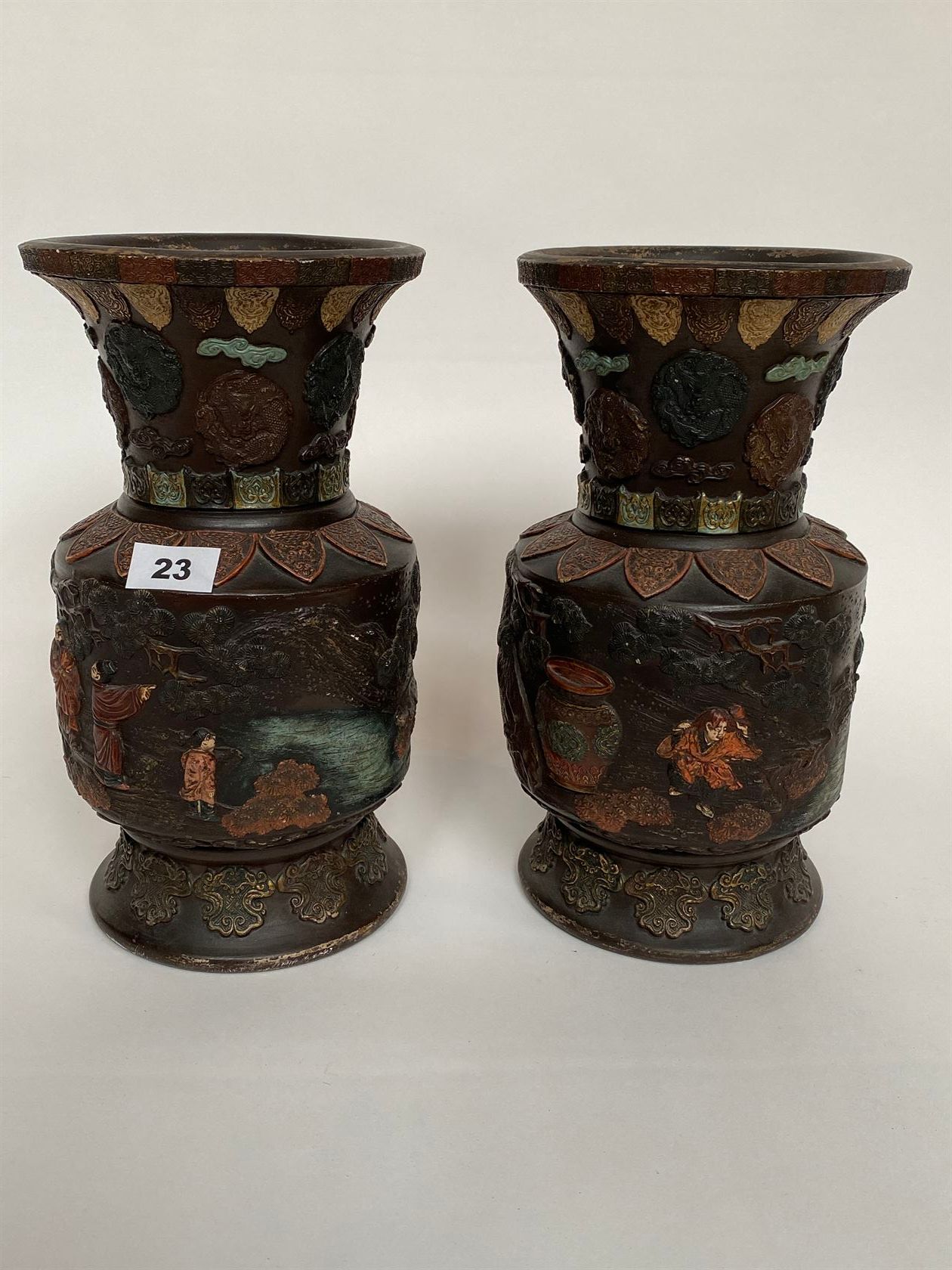 Null 一对多色彩斑的陶器花瓶，上面装饰着壁炉、奖章和人物场景（轻微磨损）。日本，19世纪末-20世纪初。高32厘米。