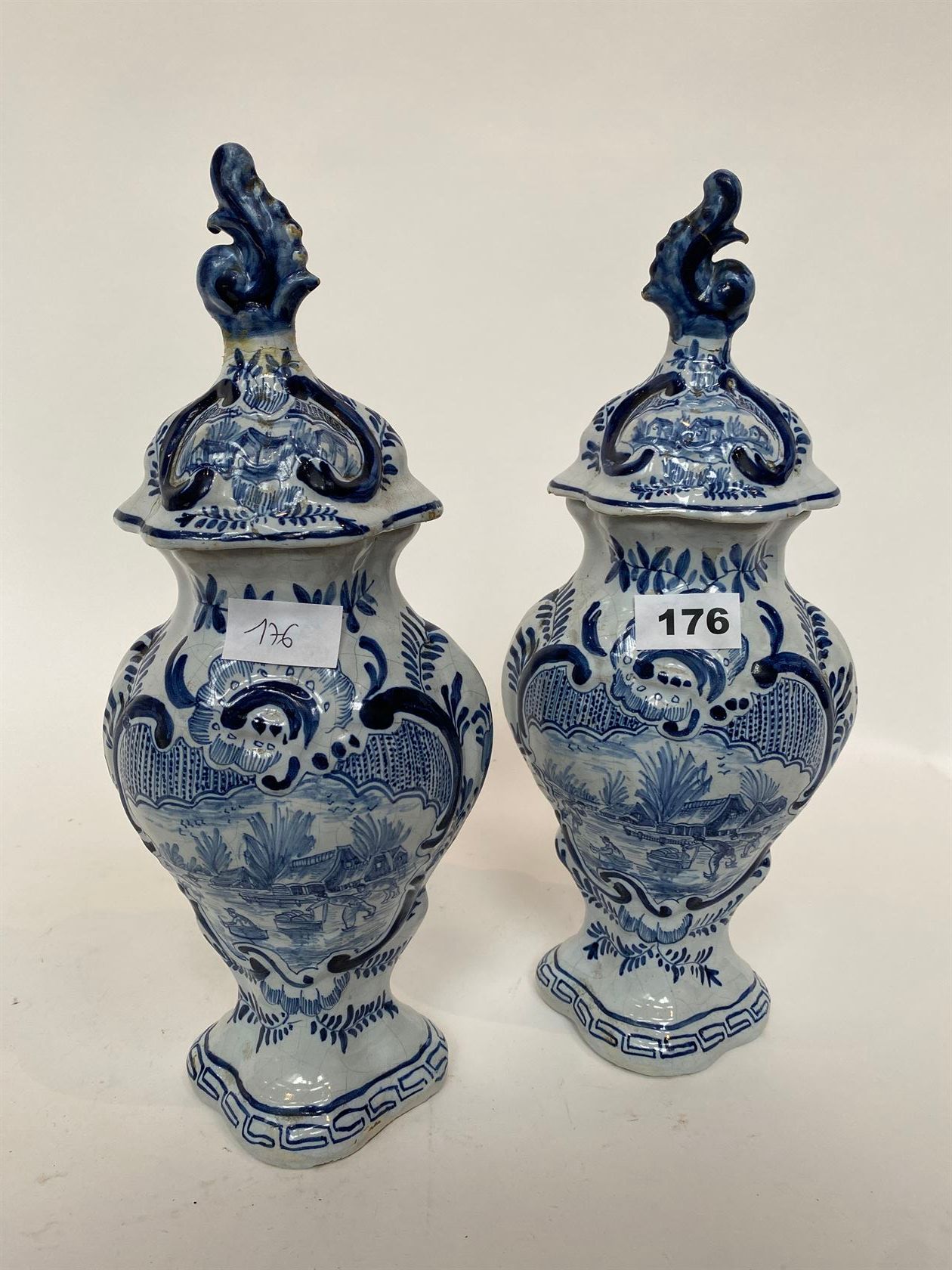 Null 一对有盖柱状花瓶，以单色蓝色装饰，上面有村庄场景和滑冰鞋（盖子已修复）。DELFT，19世纪。高37厘米。