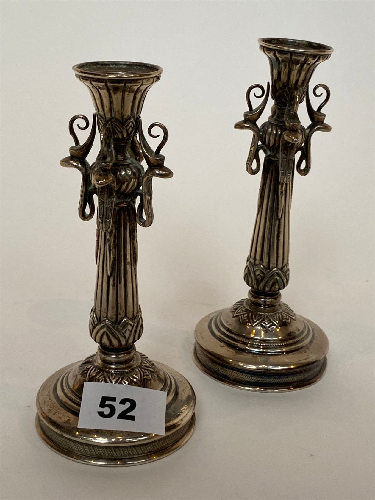 Null 一对小银烛，埃及，20世纪初，站在圆形底座上，柱子的轴上有莲花图案和四个冠状眼镜蛇头。众多的标志，包括象鼻虫。重量 388 g.高度：17厘米。