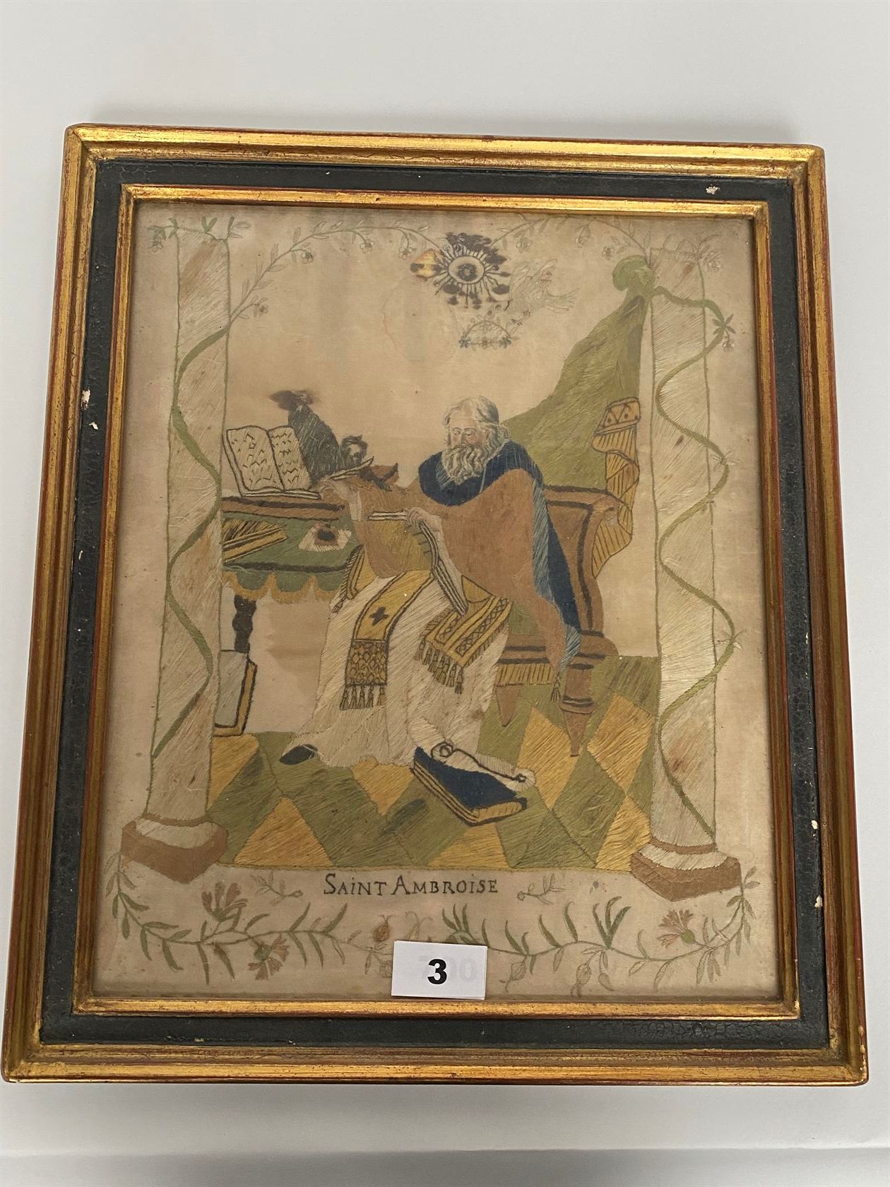 Null 彩色丝绸刺绣，表现圣安布罗斯在他的办公桌前，圣灵在他身上飞翔（小事故，污渍），装在一个框架中。十八世纪。尺寸为35 x 29厘米。