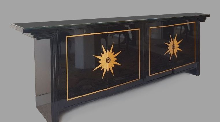 Null 一个直立的黑漆木制边柜，有圆角和太阳纹装饰，有凹槽的立柱，前面有四片叶子（腿的底部有轻微损坏）。高81厘米。宽度240厘米。深度44厘米。